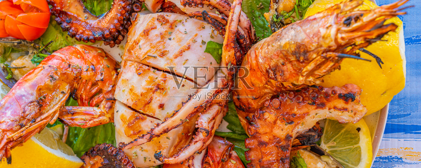 海鲜拼盘配烤鱿鱼，章鱼，大虾和青口配柠檬沙拉照片摄影图片