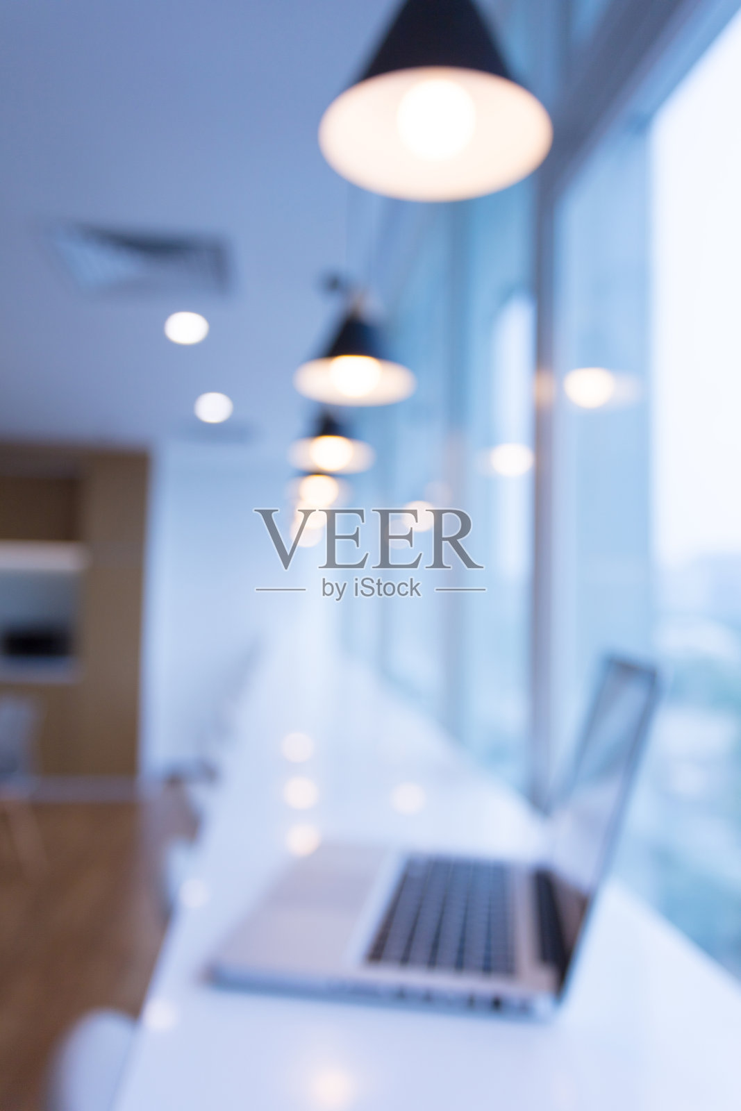 笔记本电脑在新建的现代化办公大楼，公司的商务桌靠近玻璃窗户照片摄影图片