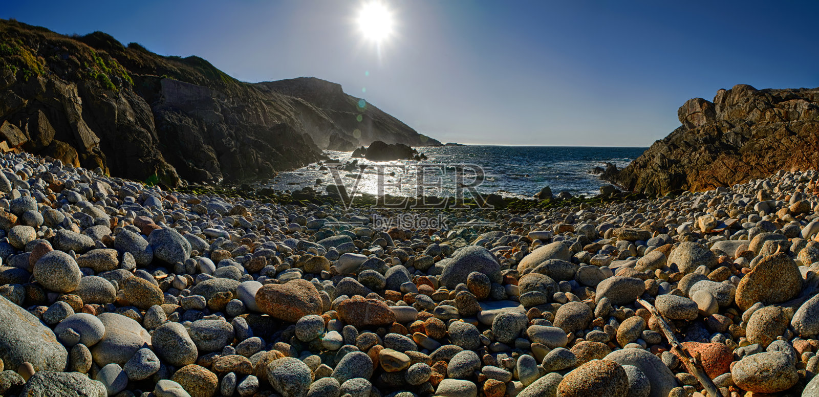 海岸上散布着五颜六色的圆形石头照片摄影图片