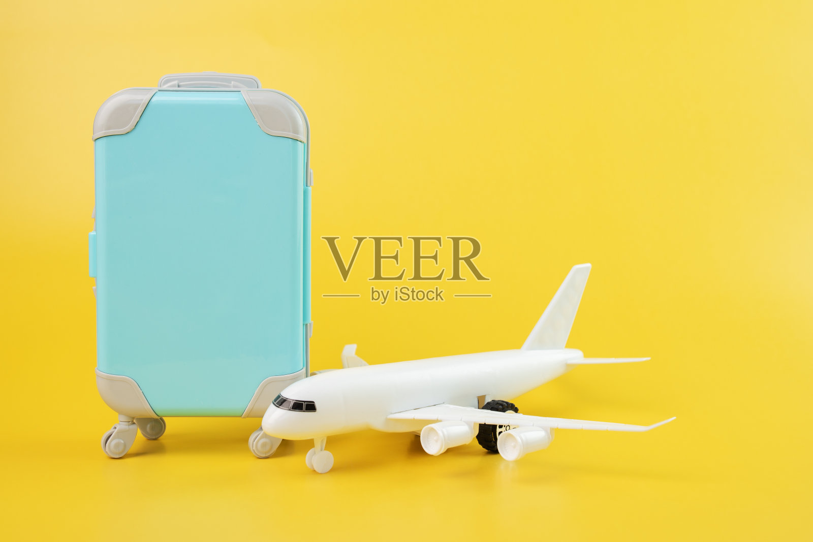 黄色背景的飞机和行李箱，旅游和旅游照片摄影图片