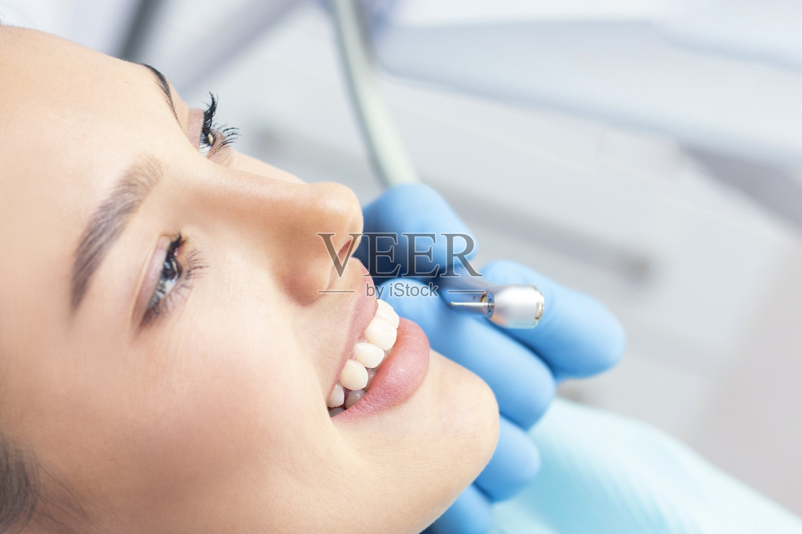 牙科诊所的牙医和病人。由牙医检查牙齿的妇女照片摄影图片