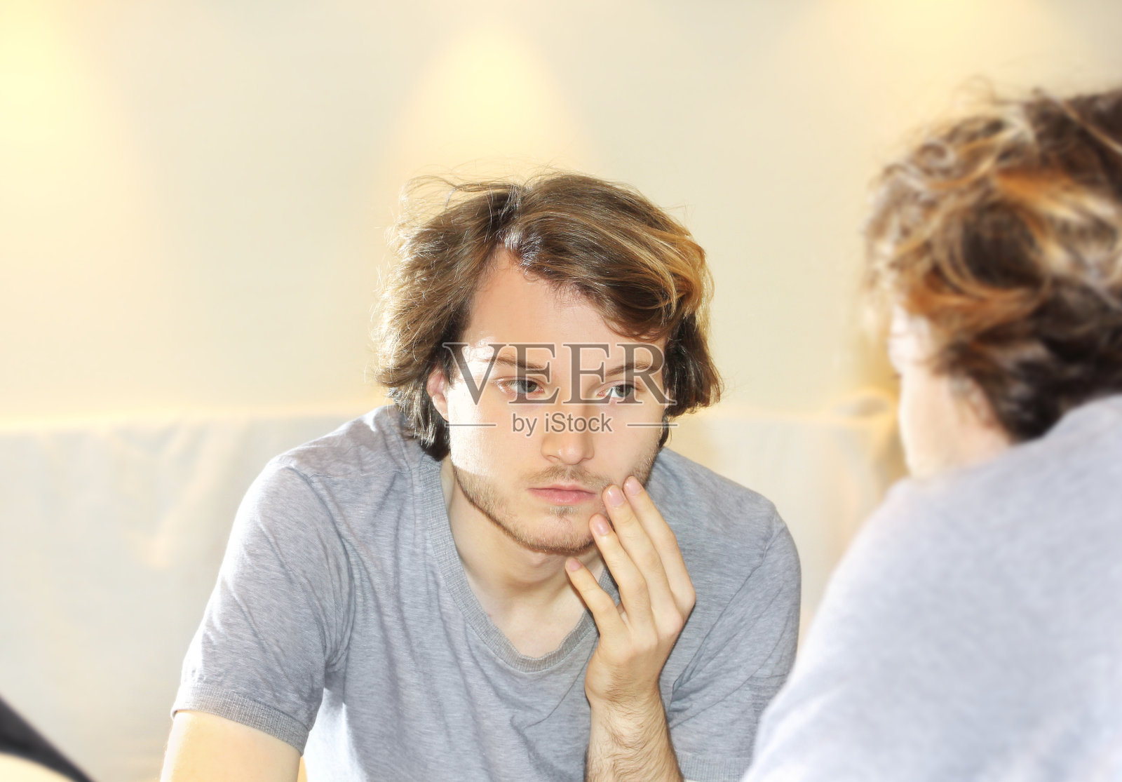 年轻人看着镜子，梳头发，看着脸上的问题照片摄影图片