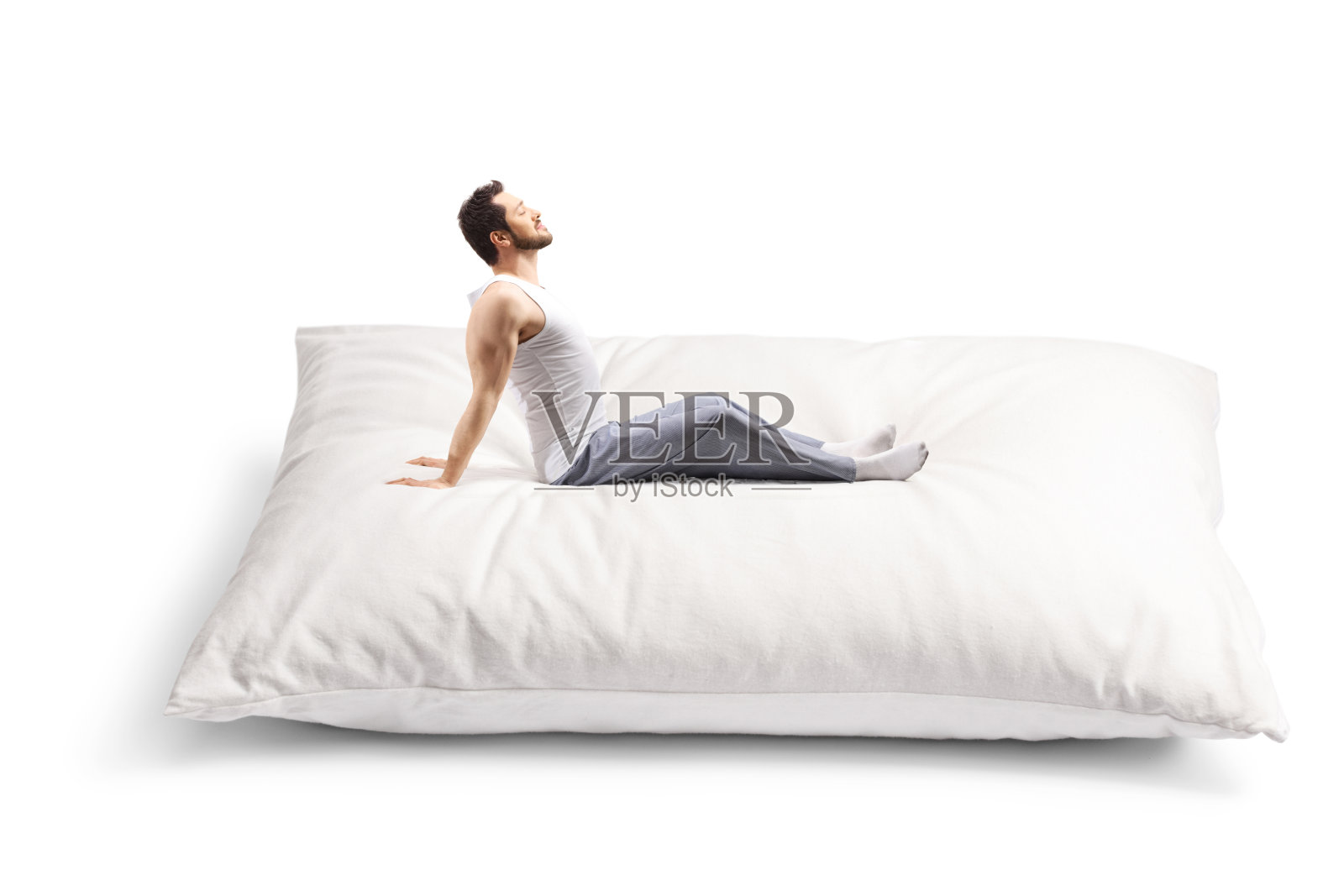 穿着睡衣躺在大枕头上的年轻人照片摄影图片