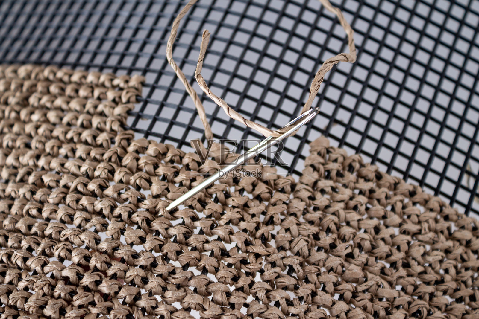 用拉菲纱在塑料画布上挑花的过程，选择性对焦照片摄影图片