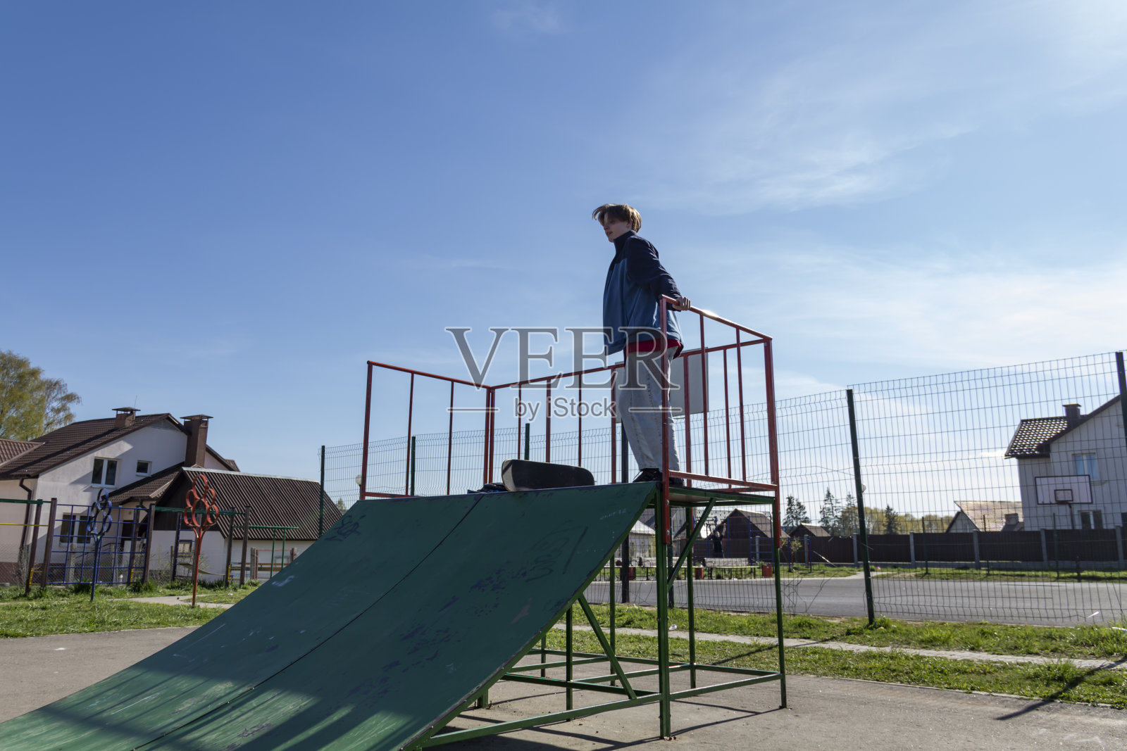 一个年轻人独自在街上积极地玩滑板。照片摄影图片