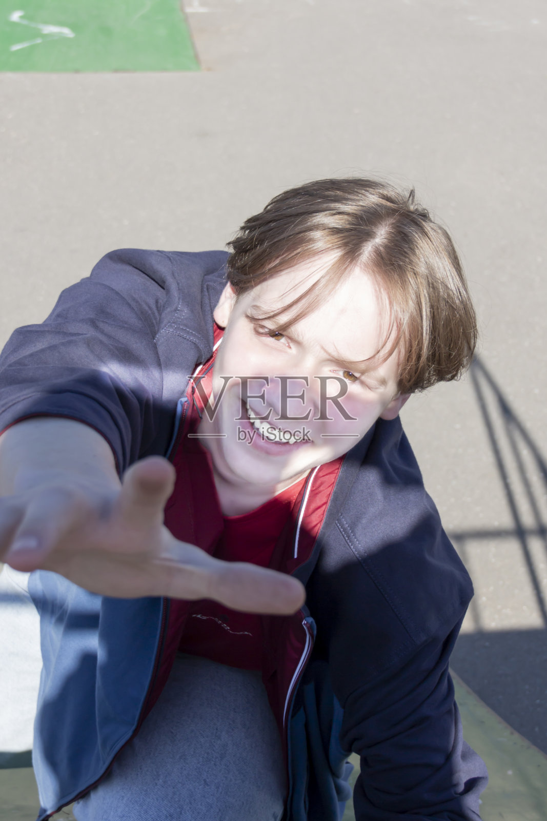 一个年轻人独自在街上积极地玩滑板。照片摄影图片