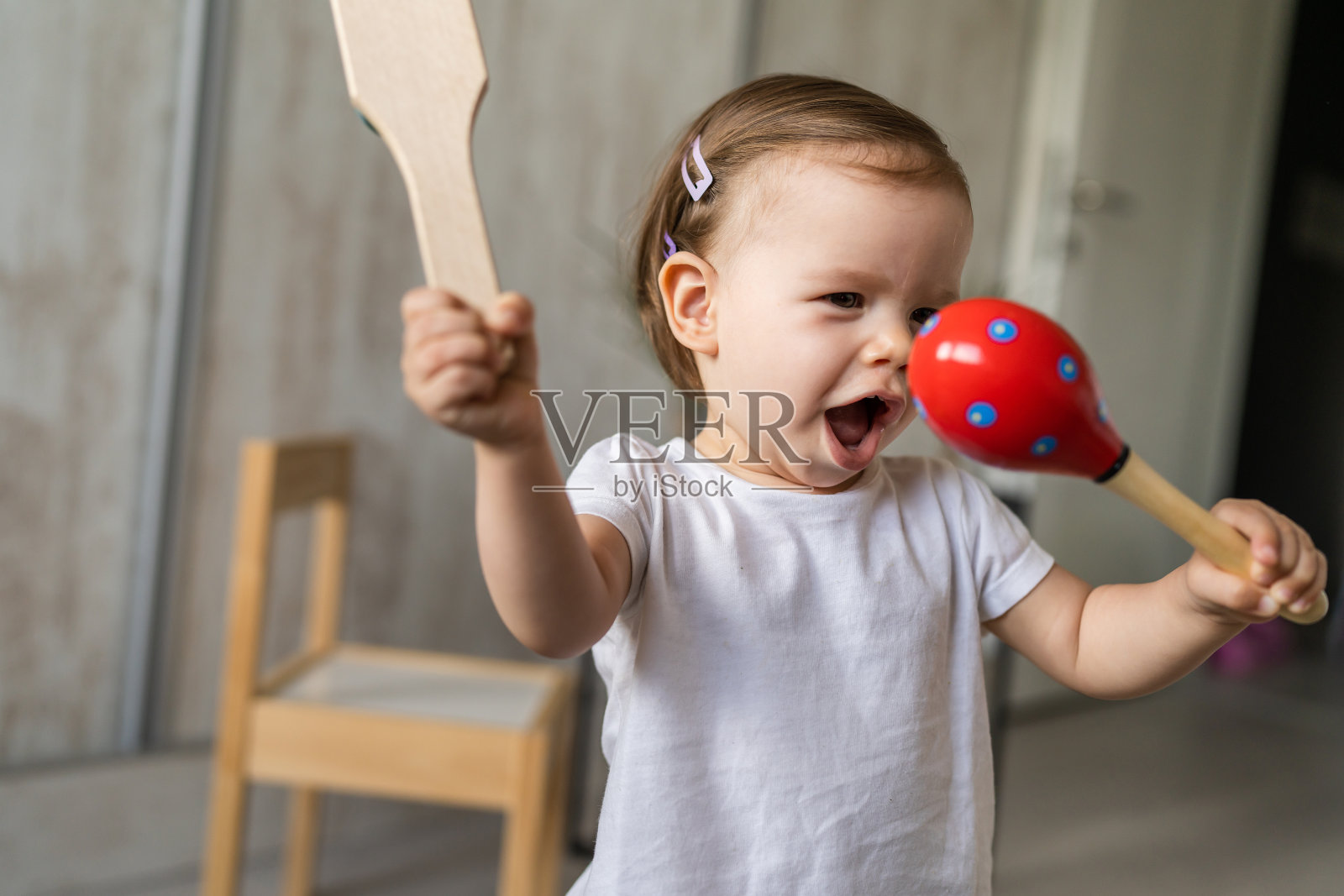 一个女孩小白人孩子小蹒跚学步的孩子在家里玩木制拨浪鼓玩具拷贝空间照片摄影图片