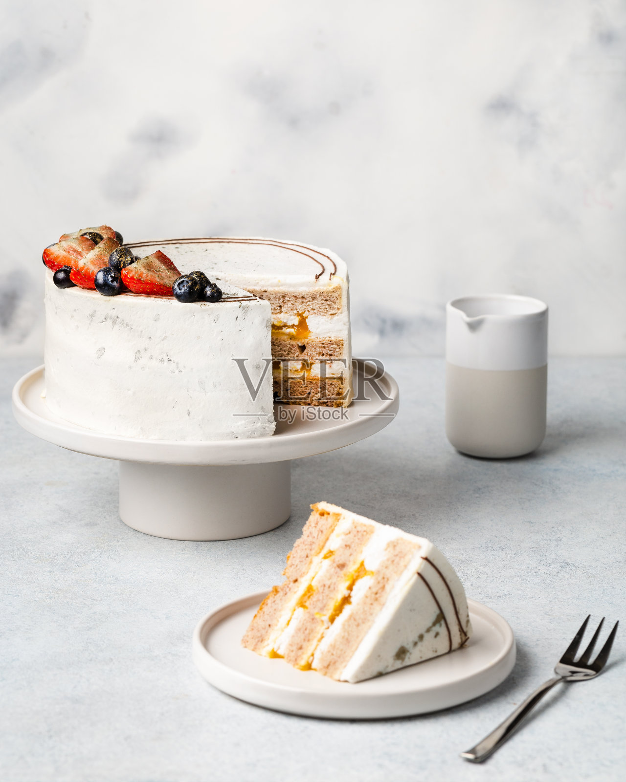 白色的节日蛋糕，在明亮的背景上装饰着浆果。糖果的概念照片摄影图片