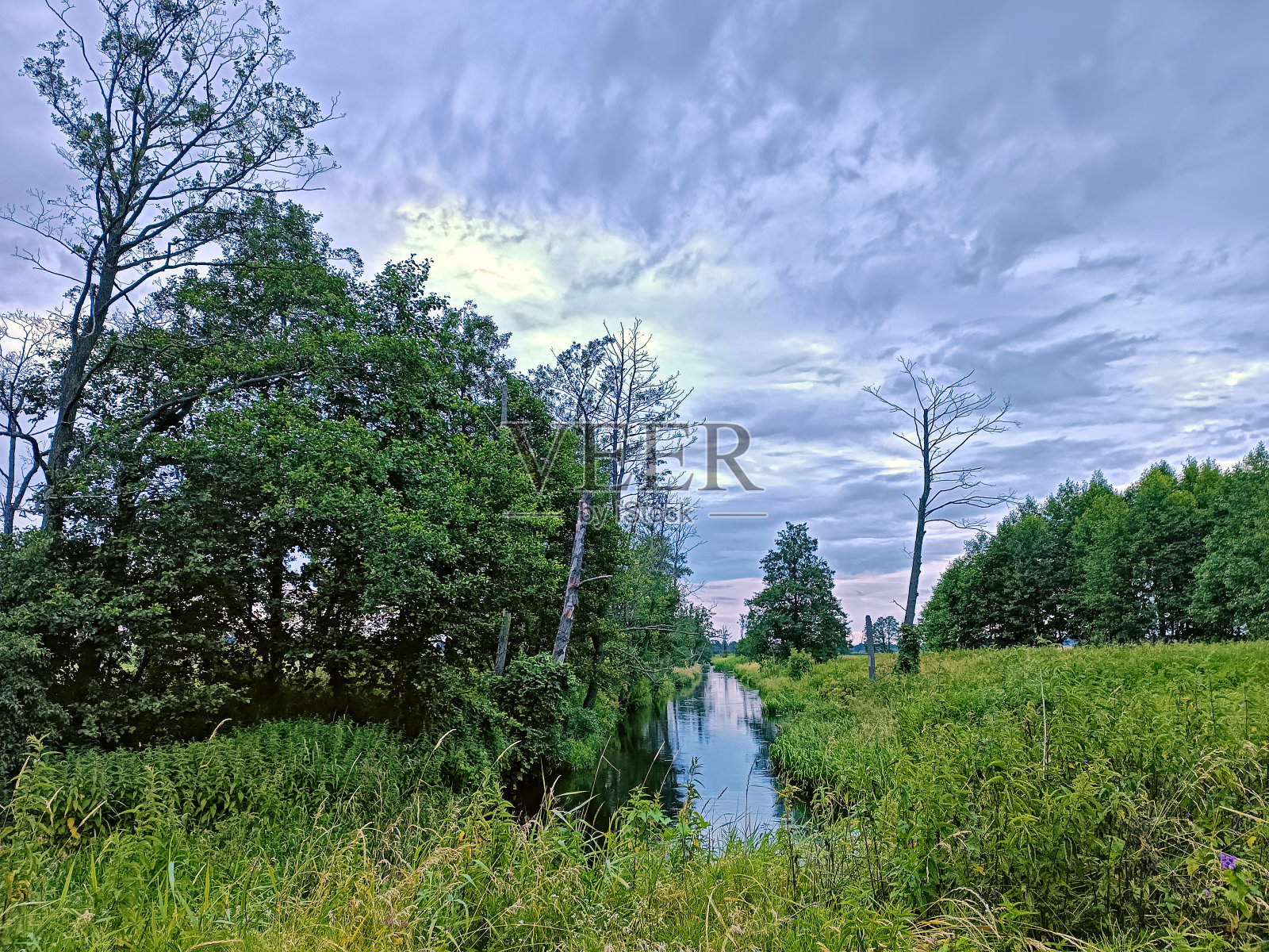 风暴阴雨天气。夏季阴天。小河在树林里。山水戏剧性，多云天。照片摄影图片