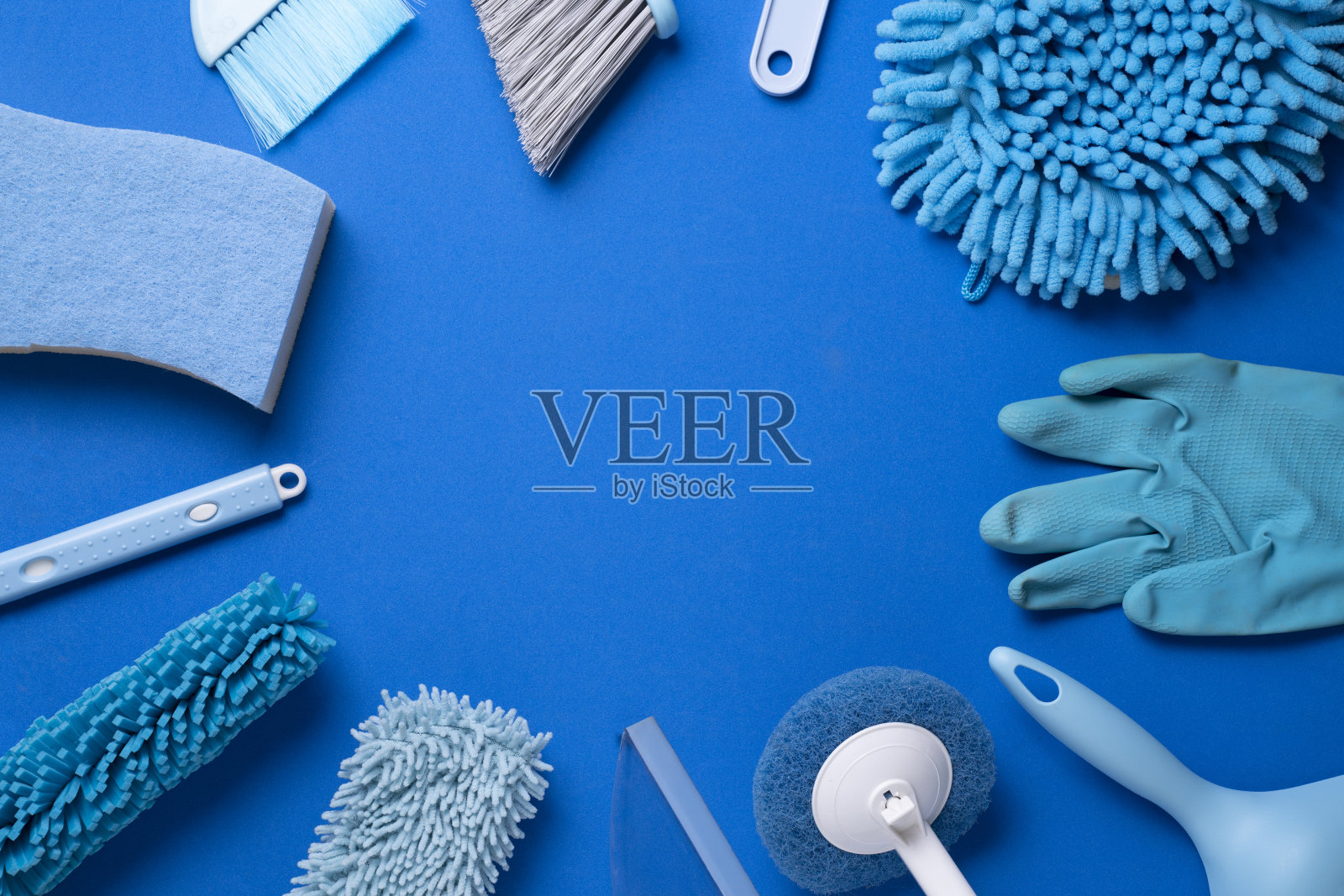 房子清洁塑料产品的木桌子上的蓝色背景，家庭服务或家政概念照片摄影图片