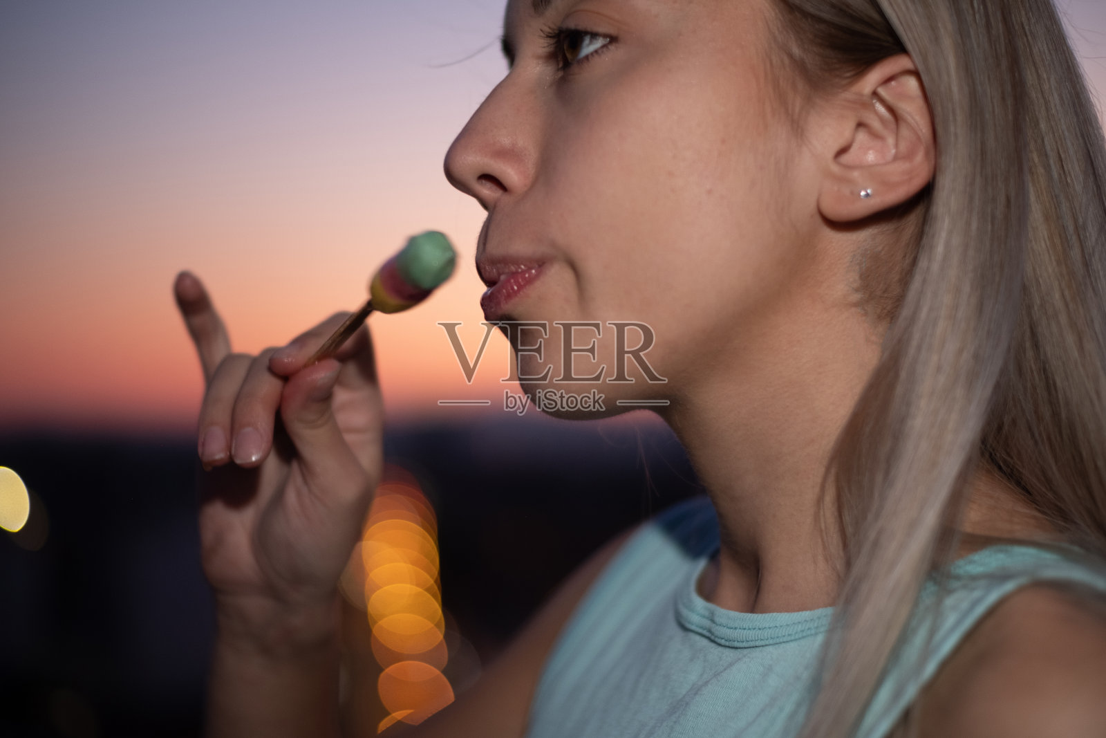 一个年轻女子在晚上舔冰淇淋的特写肖像照片摄影图片