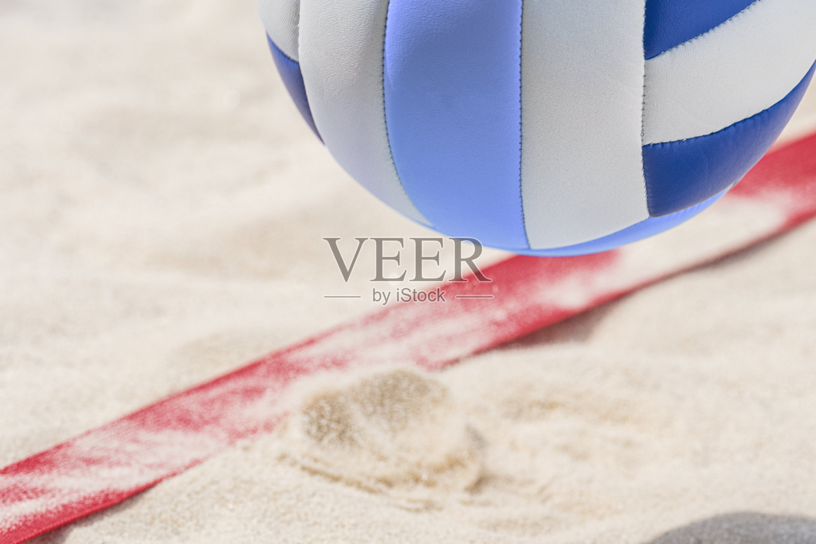 空中沙滩排球:在沙滩球场内的半空中打到底线的沙滩排球照片摄影图片