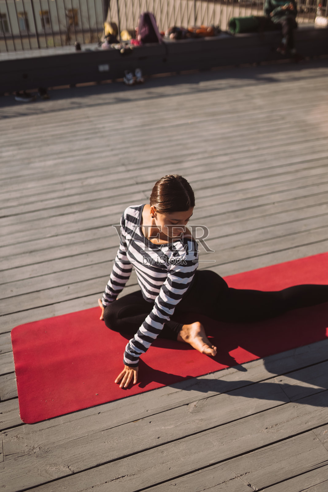清晨，一名女子在屋顶上做瑜伽照片摄影图片