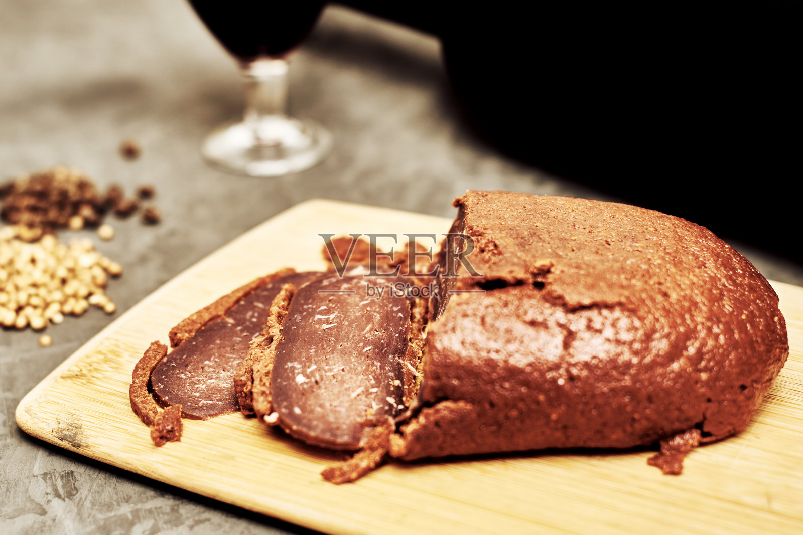 在切菜板上切成片，旁边放着一瓶酒和一个玻璃杯照片摄影图片