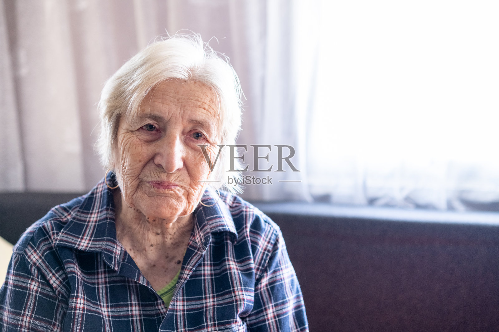 一位感恩的老妇人在家的肖像。照片摄影图片