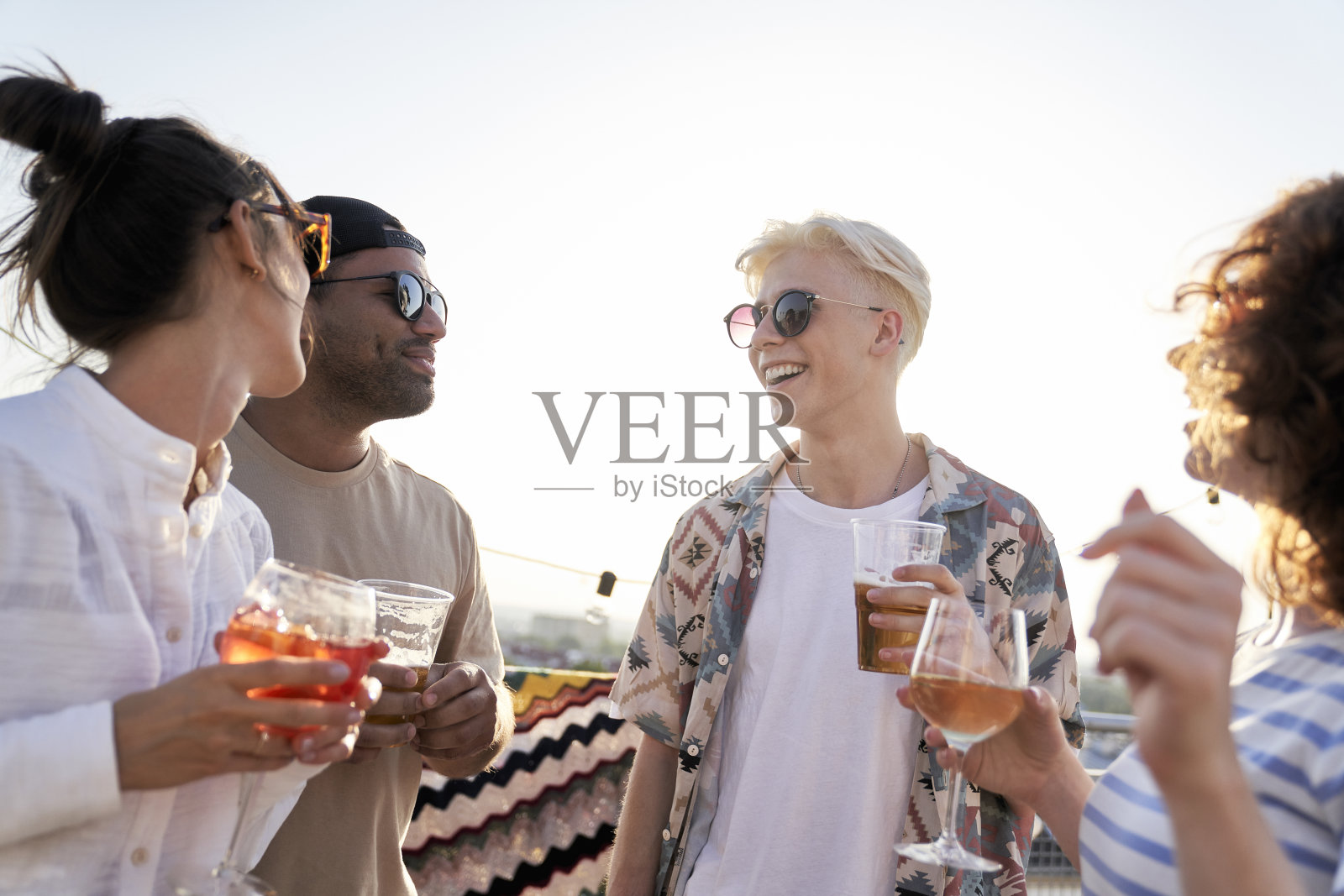 一群来自不同种族的朋友在屋顶上聚会照片摄影图片