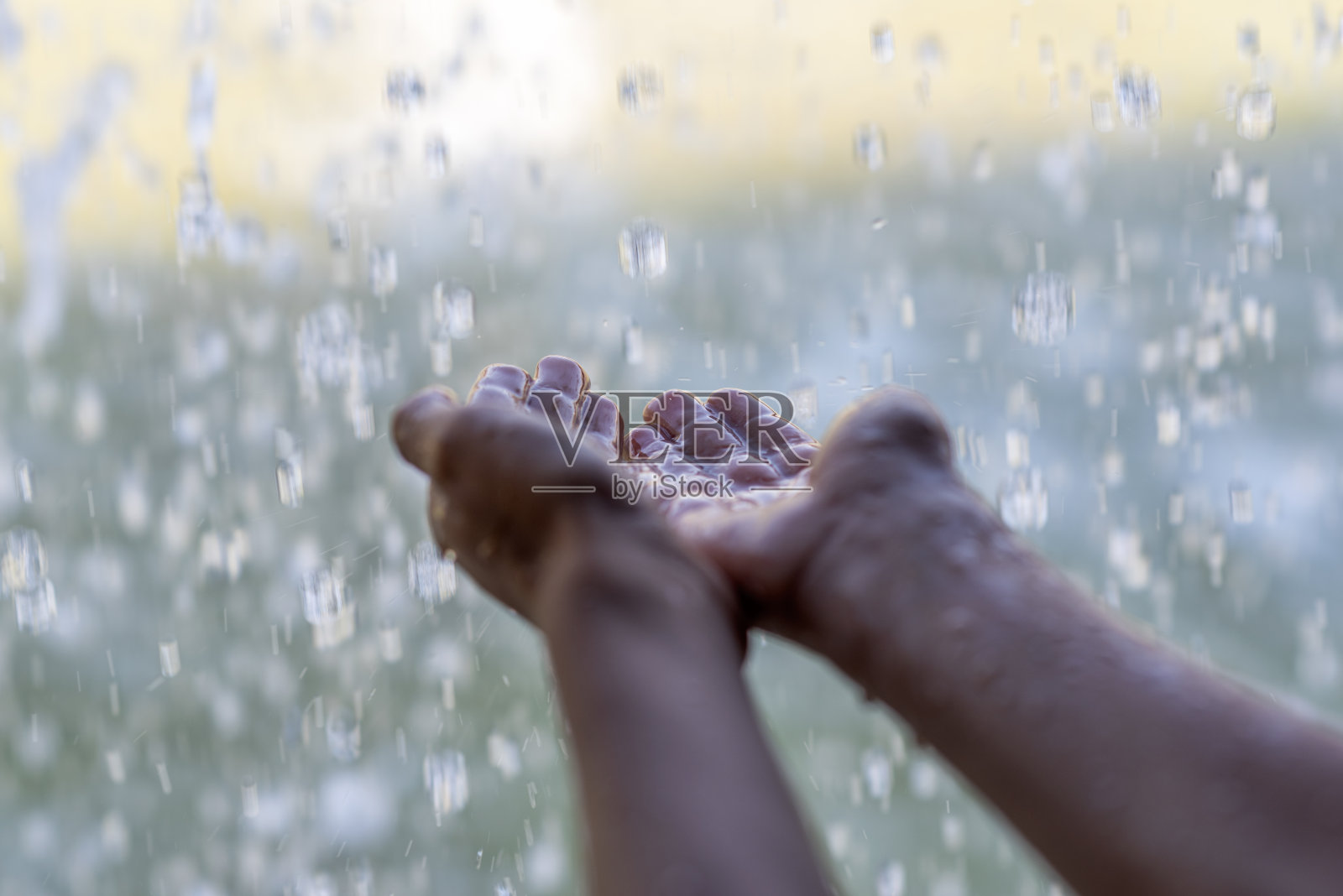 男孩把手伸进从瀑布流出的水里照片摄影图片