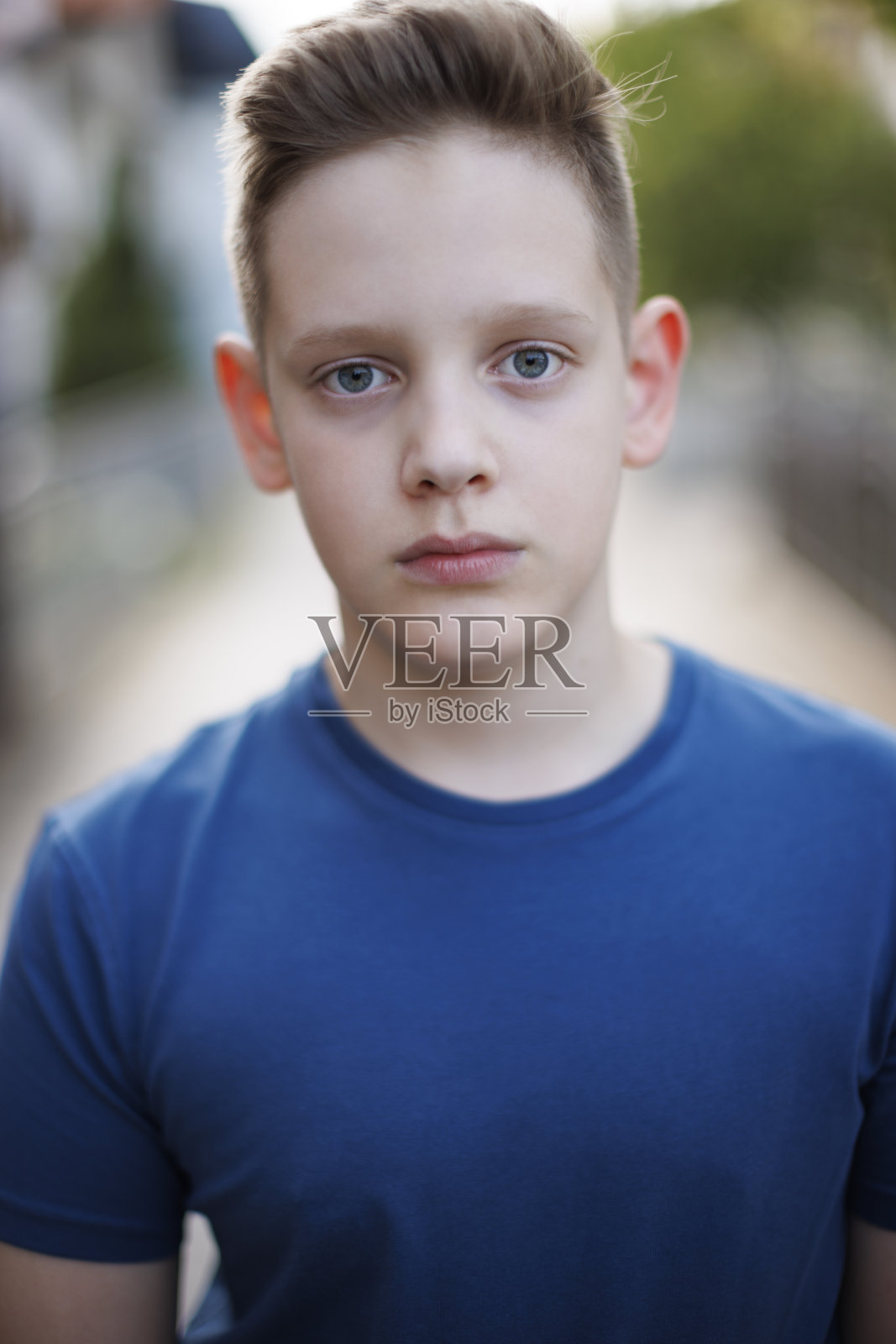 一个蓝色眼睛的男孩的特写肖像认真地看着相机照片摄影图片