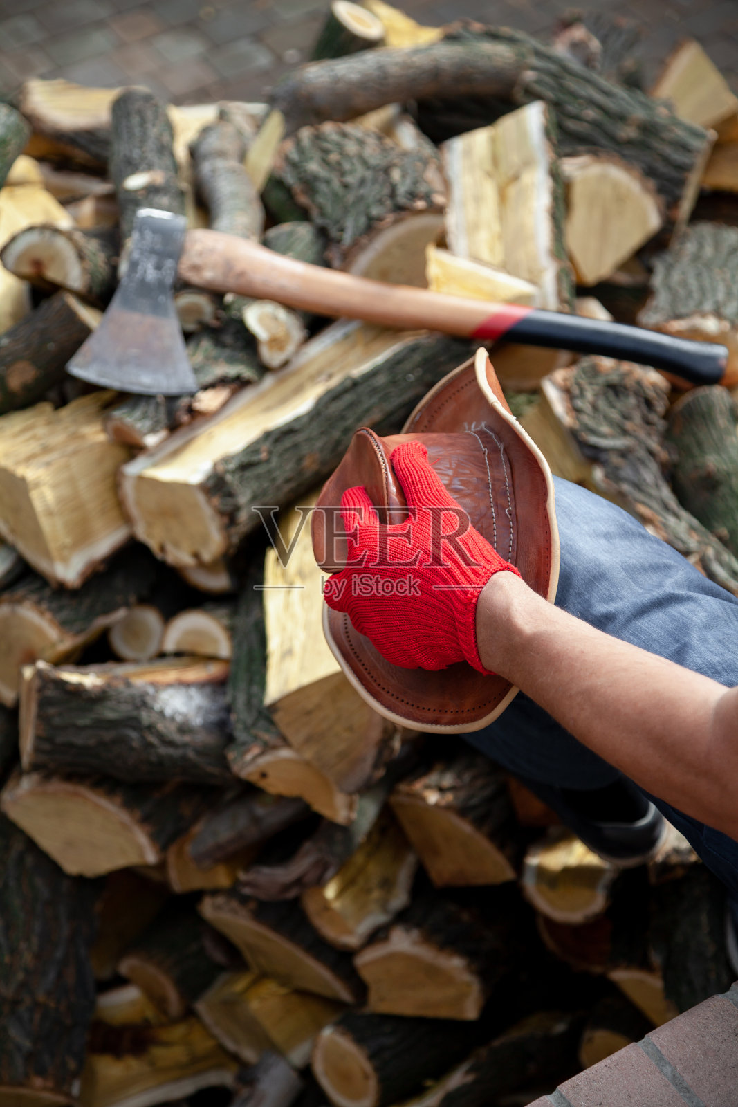 一个戴着红色手套的人坐在一堆柴火上照片摄影图片