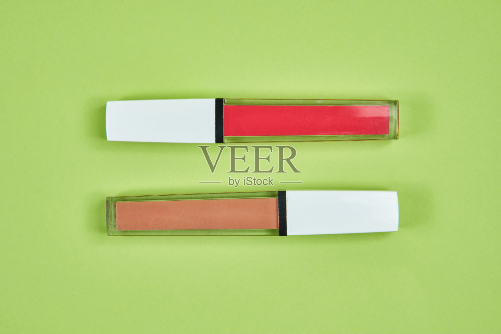 两个口红粉红棕色图案在绿色背景上隔离照片摄影图片