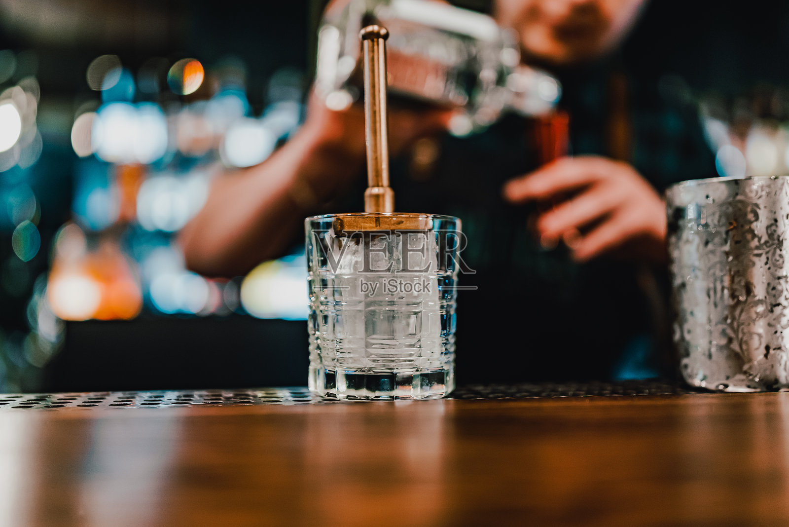 男子酒保手工制作内格罗尼鸡尾酒。尼格罗尼经典鸡尾酒和杜松子酒搭配甜苦艾酒，红色苦利口酒照片摄影图片