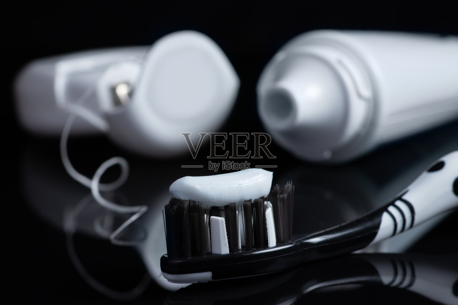 黑色背景的牙膏和牙线牙刷照片摄影图片