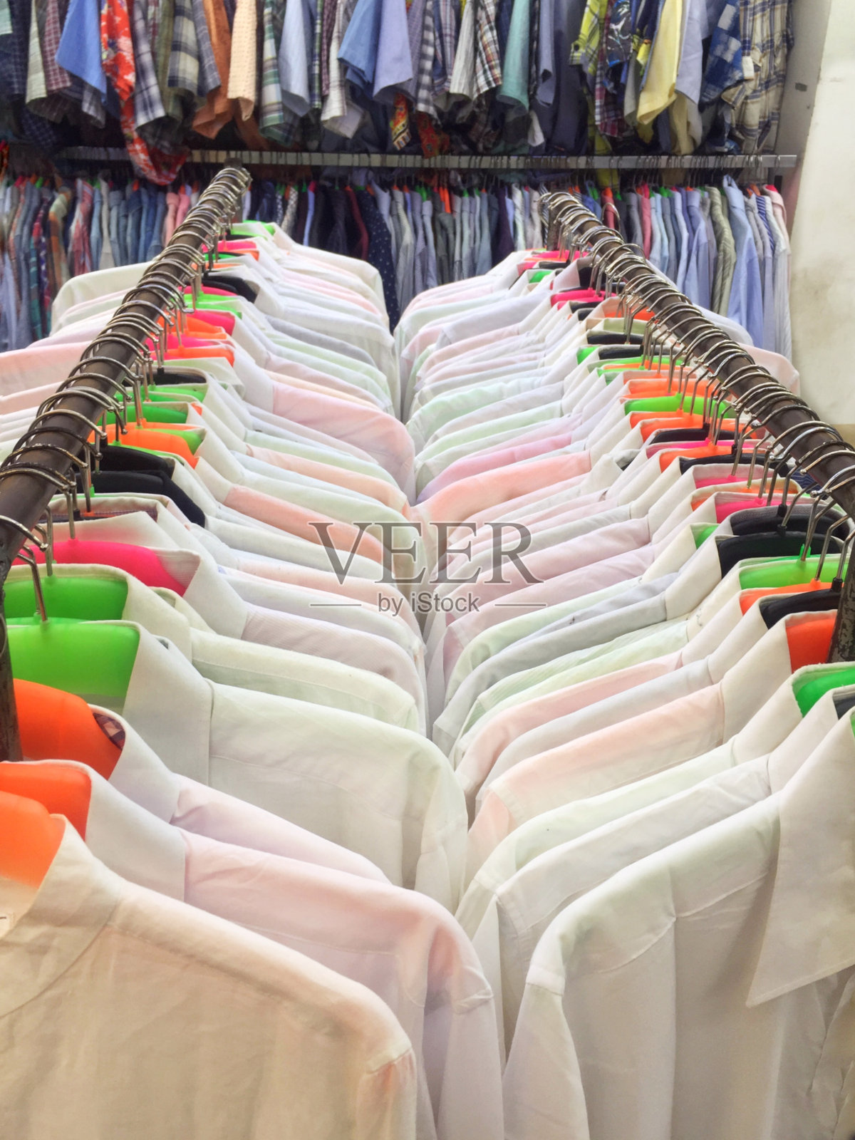 衣服白衬衫整齐地挂在衣架上。照片摄影图片