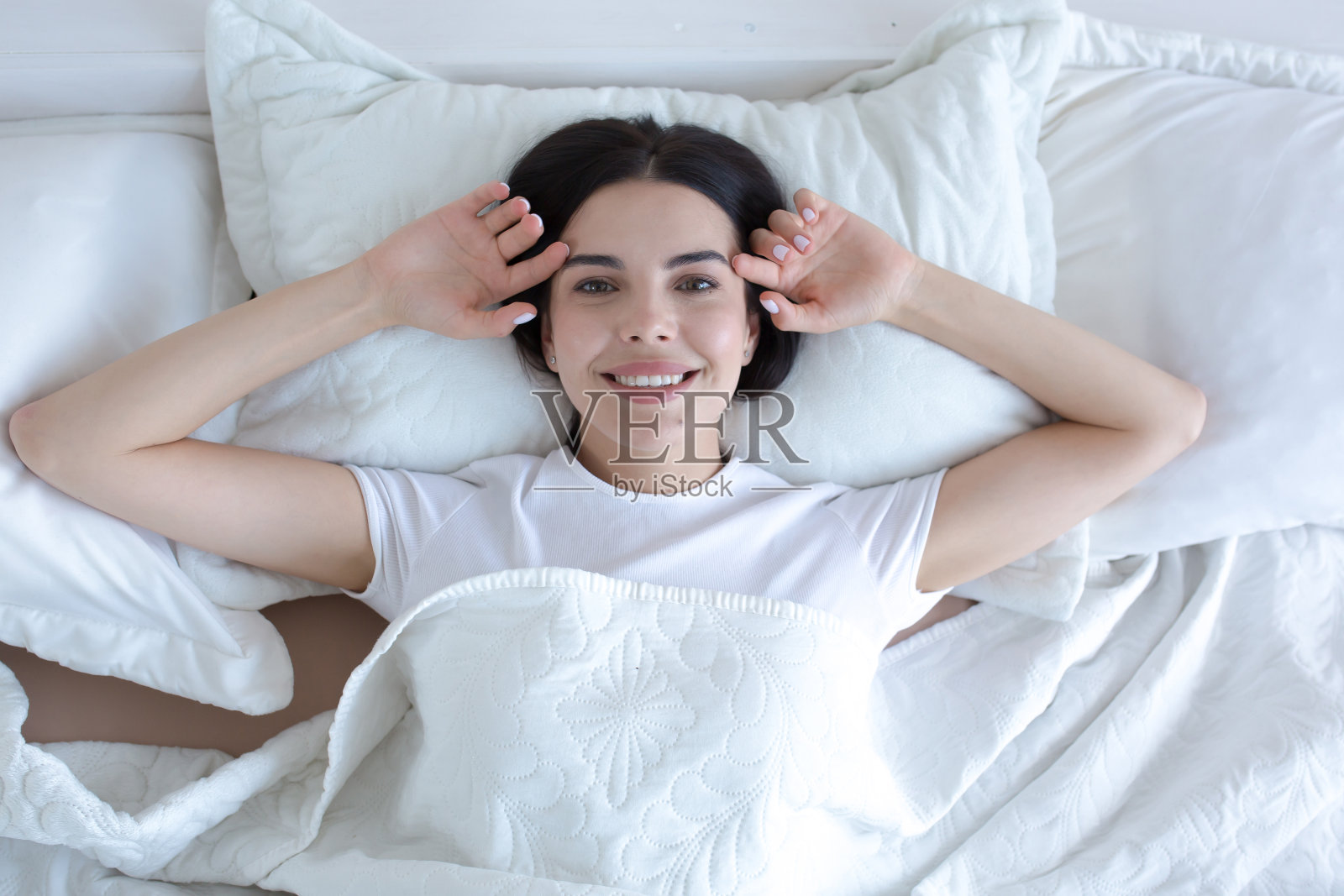 俯视年轻美丽的女人在早上昏昏欲睡微笑着看着相机照片摄影图片