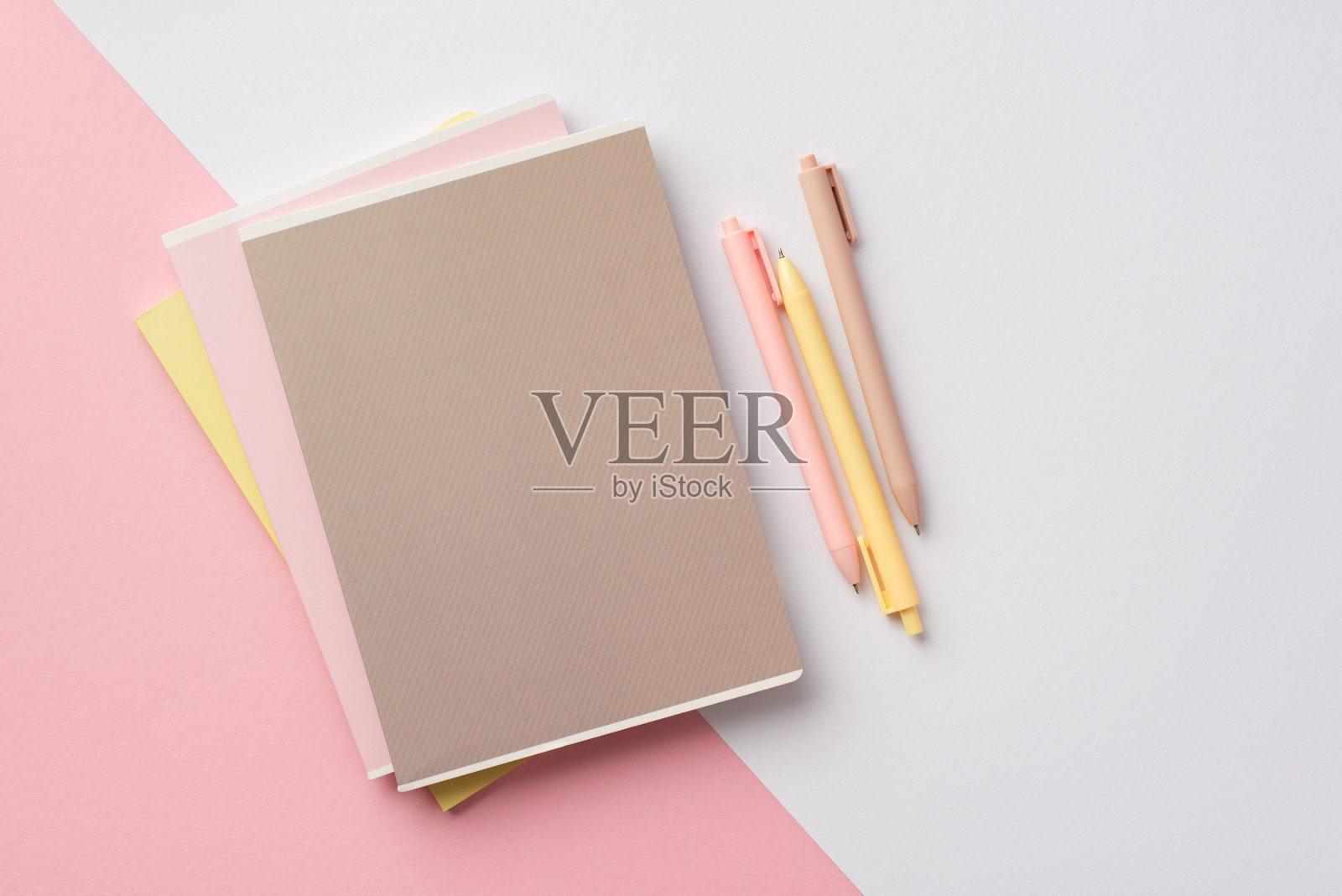 回到学校概念。俯视图照片的学校用品堆叠笔记本和笔的双色粉白背景照片摄影图片