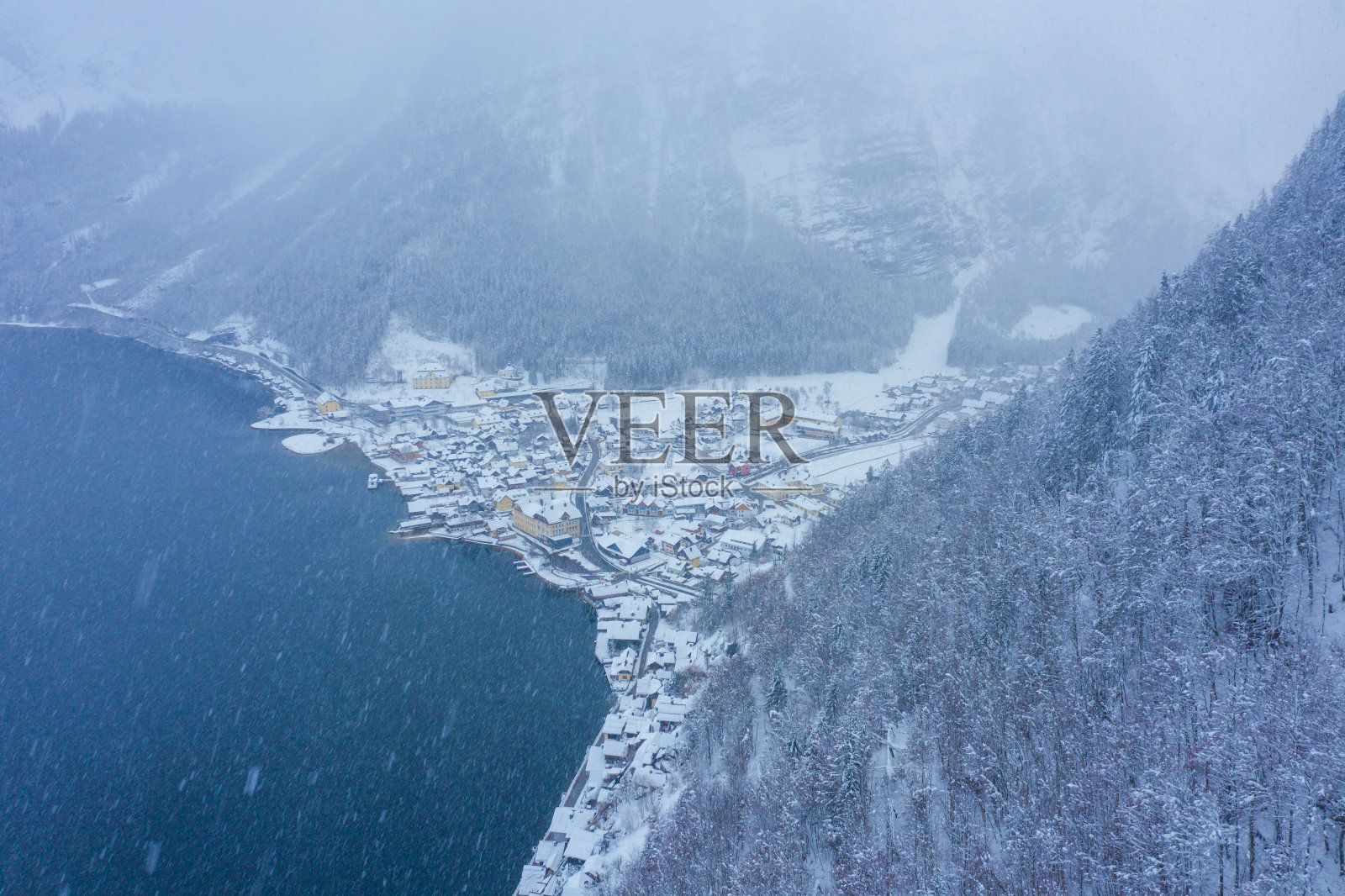 哈尔施塔特的鸟瞰图，传统的奥地利森林村庄在冬季下雪期间。照片摄影图片