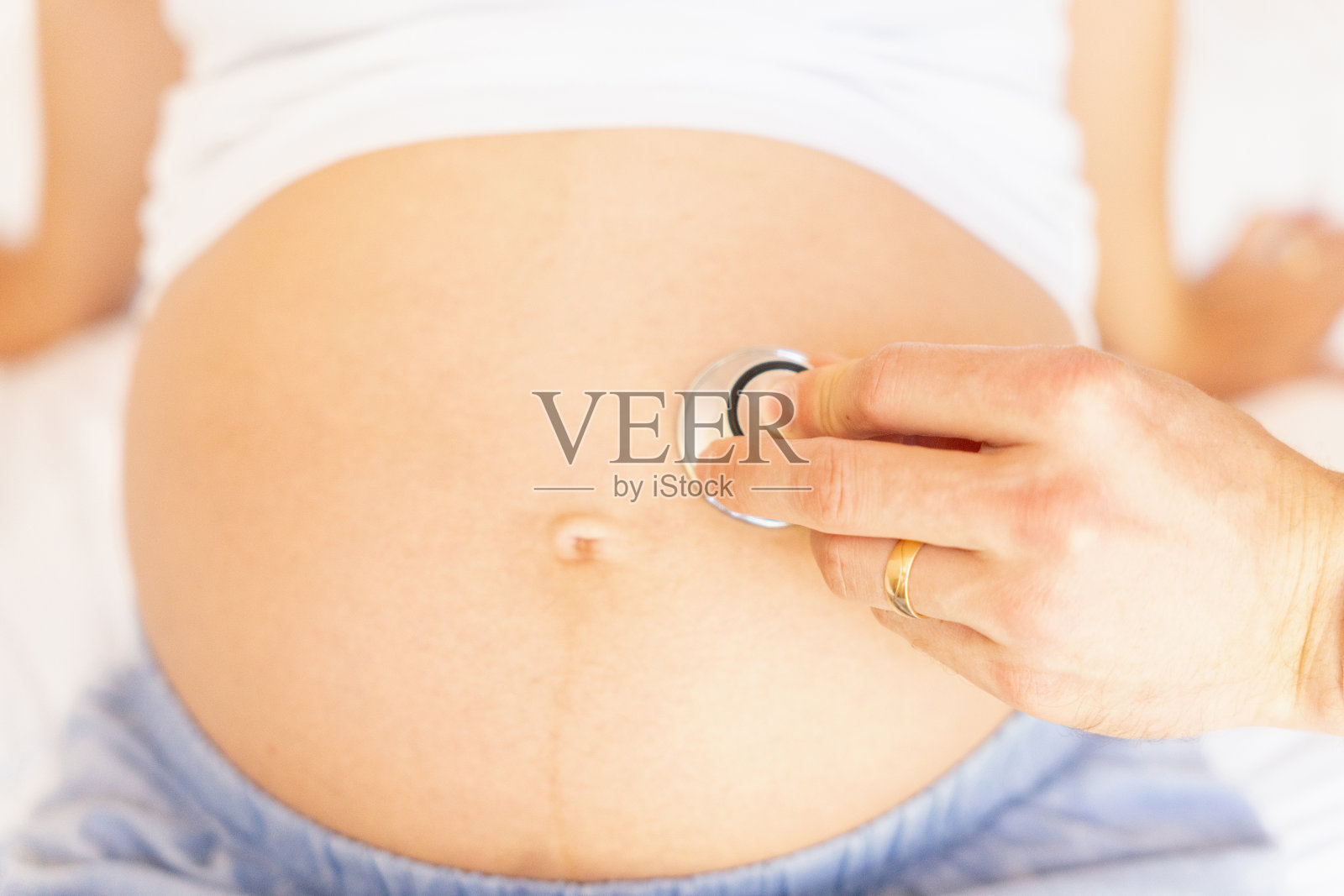 医生听诊器检查病人孕妇。怀孕顾问诊所。医生手持听诊器检查孕妇腹部。概念产妇，怀孕，分娩。照片摄影图片