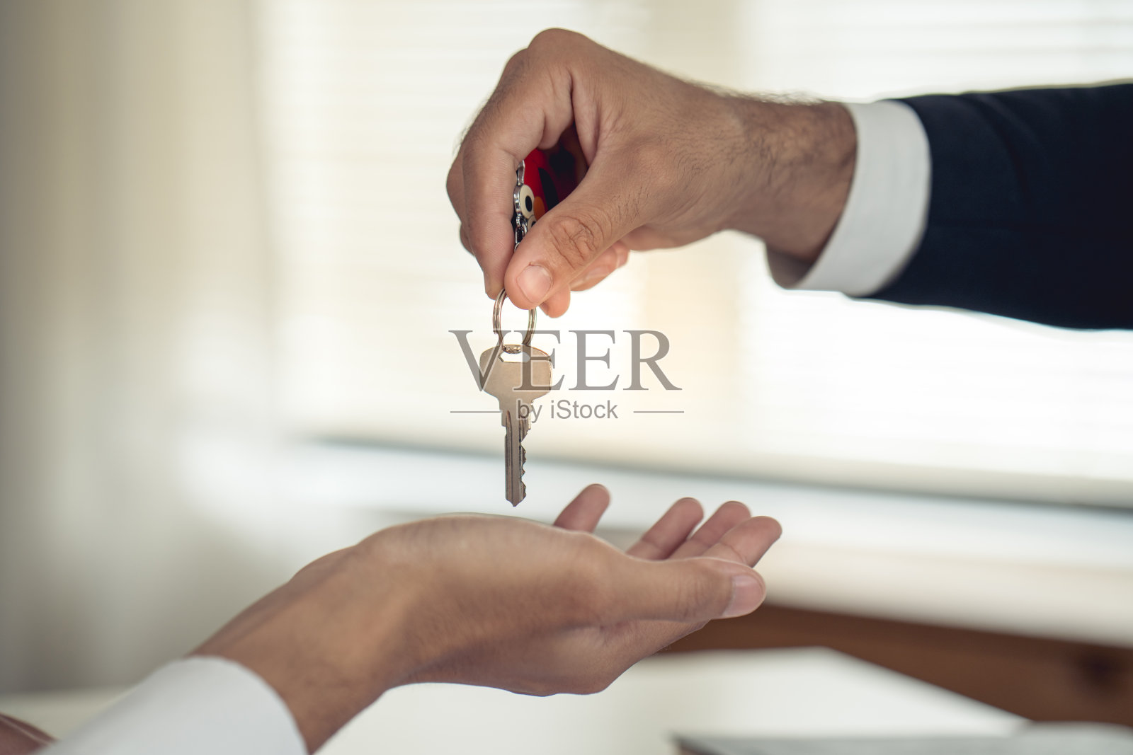 卖方将钥匙交给愿意买卖该物业的买方。照片摄影图片