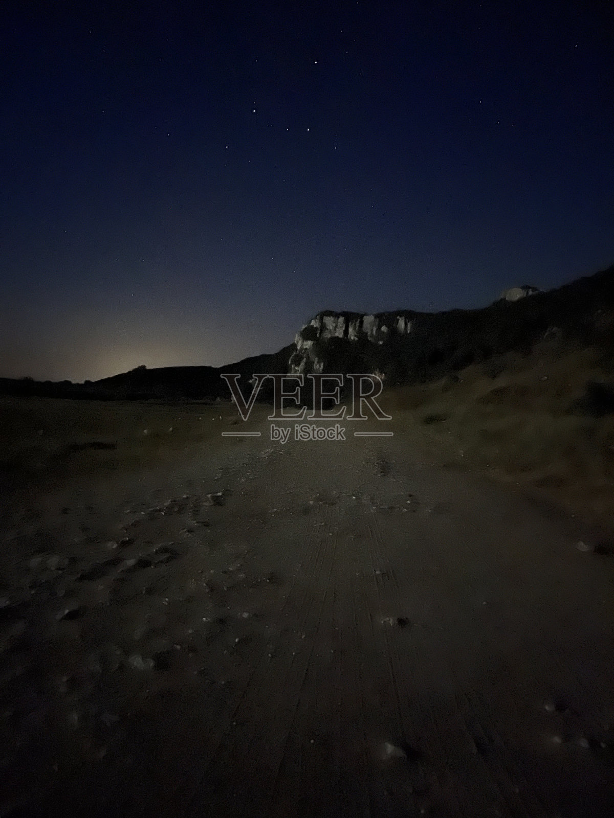 日落时印度洋沙滩上伞和棕榈树的鸟瞰图。非洲桑给巴尔的暑假。热带景观，棕榈树，阳伞，白色的沙滩，蓝色的海水，海浪照片摄影图片