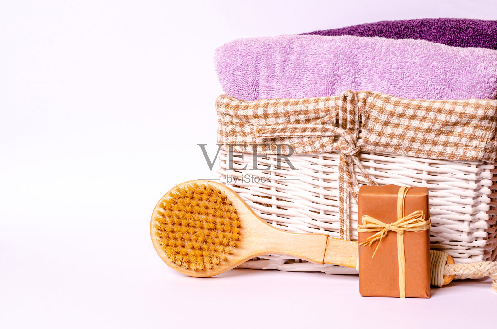 毛巾放在篮子里，木制按摩刷，白色背景的肥皂照片摄影图片