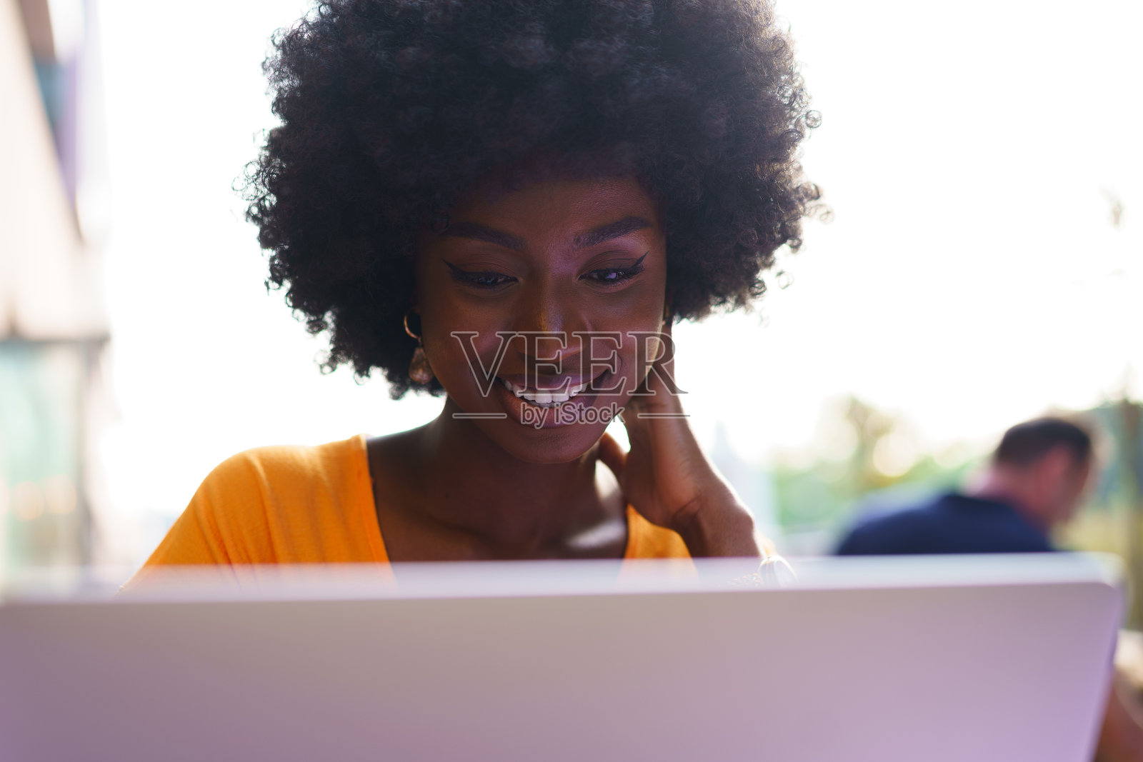 快乐美丽的年轻黑人女性使用笔记本电脑在咖啡馆照片摄影图片