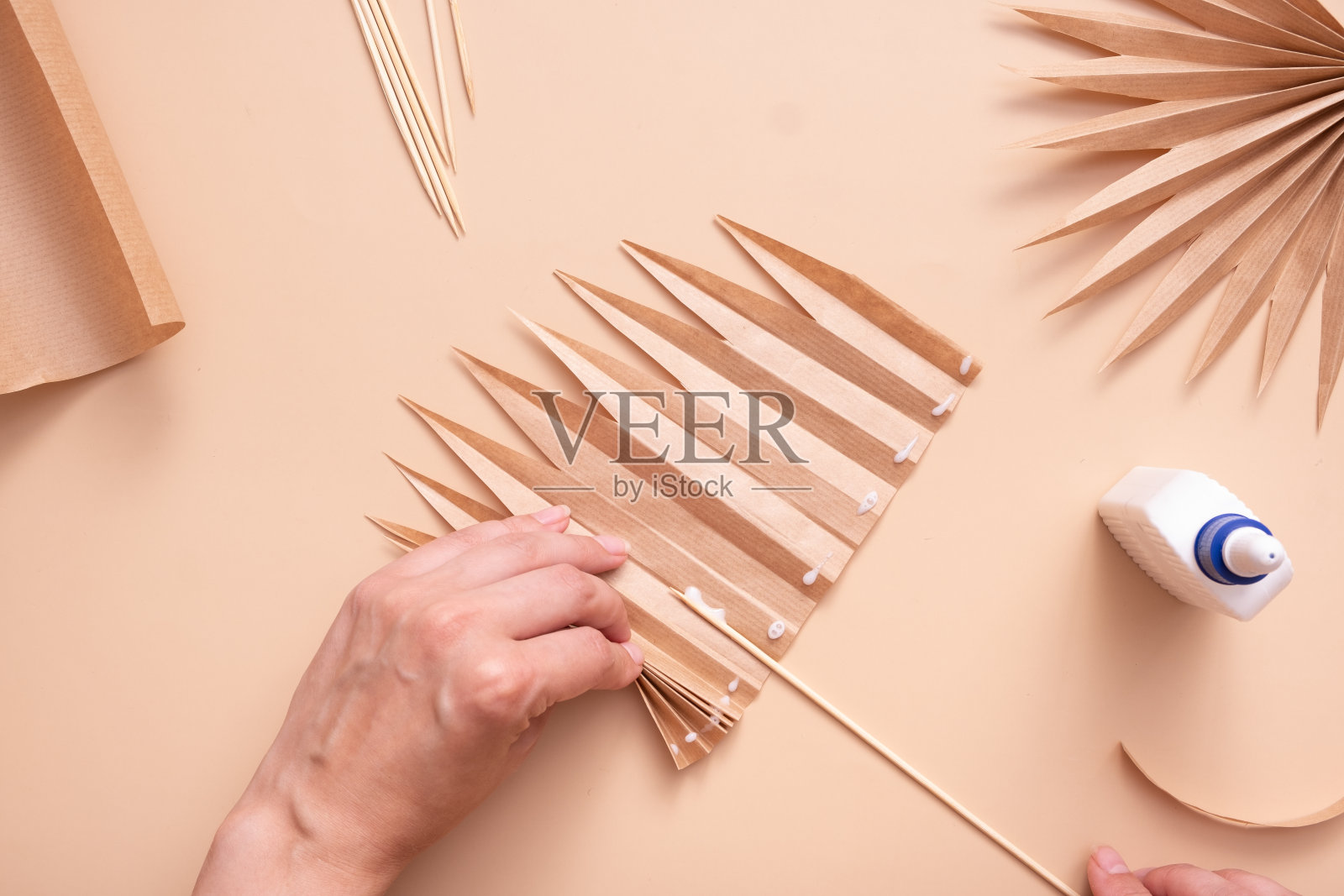 在白纸和竹签上涂上胶水。创意手工制作热带树叶。大师班照片摄影图片