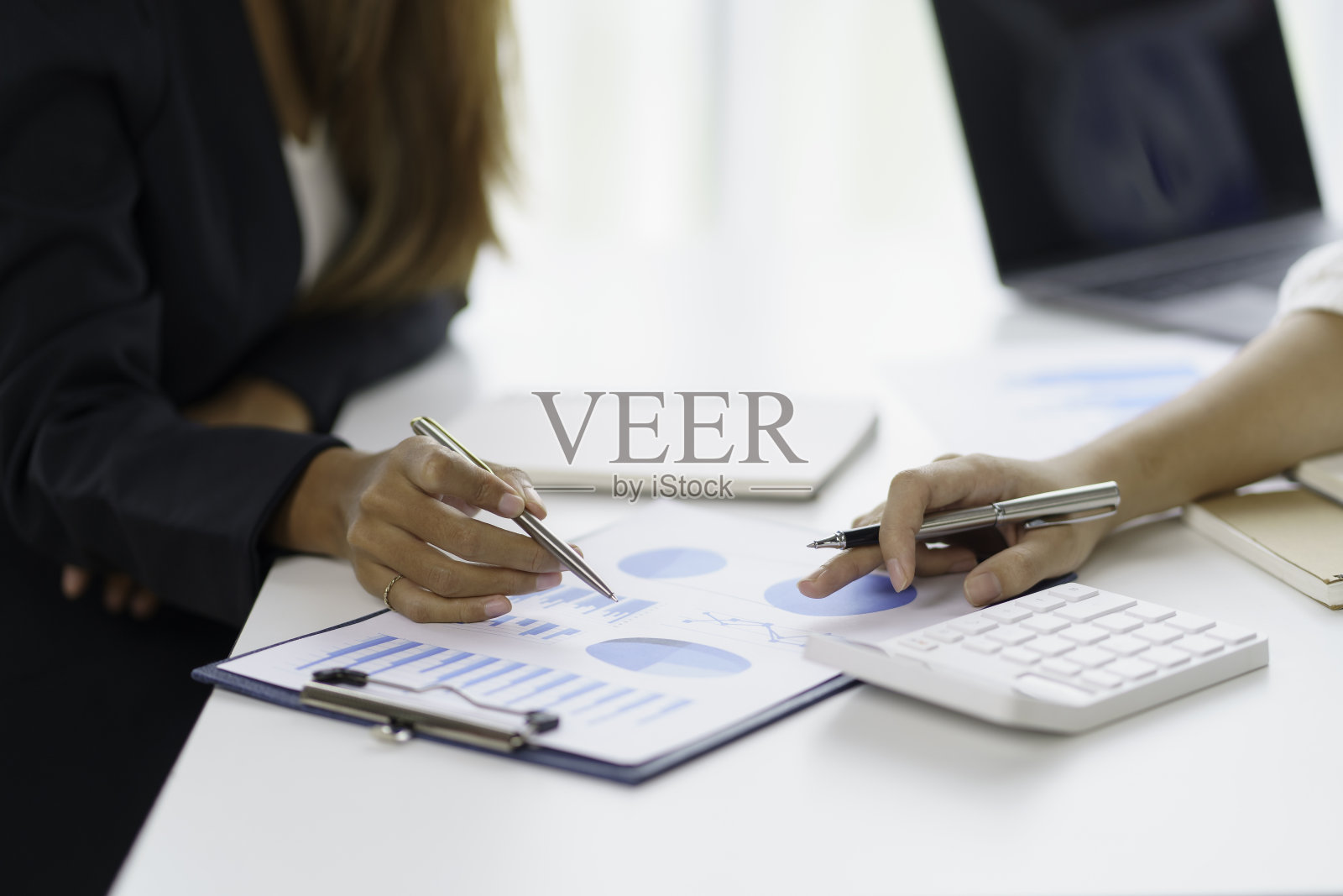 两位商界女性在会议上评估了在职企业投资和营销的状况。照片摄影图片