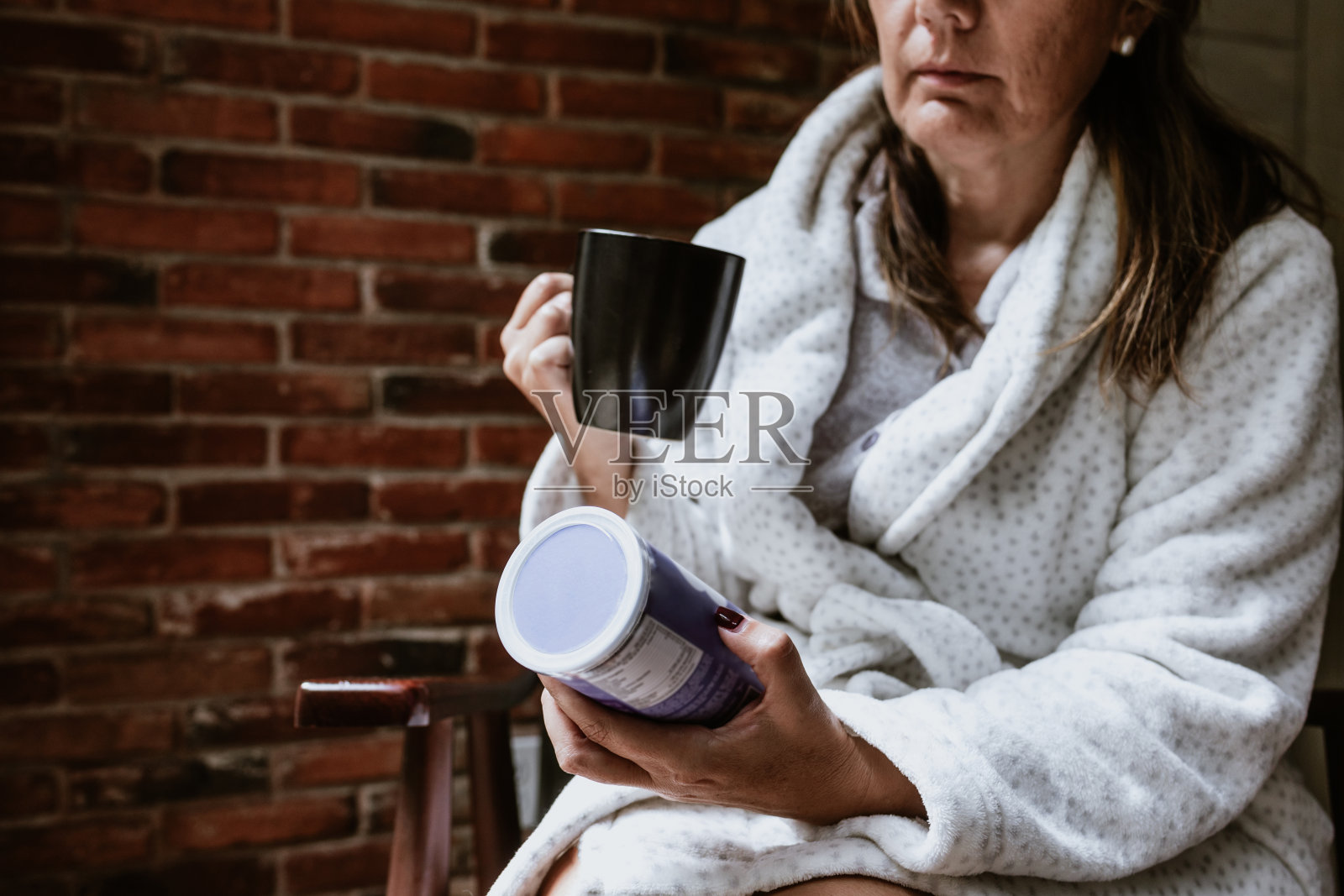 墨西哥拉丁美洲悠闲的西班牙成熟中年妇女在家读书喝茶坐在卧室照片摄影图片