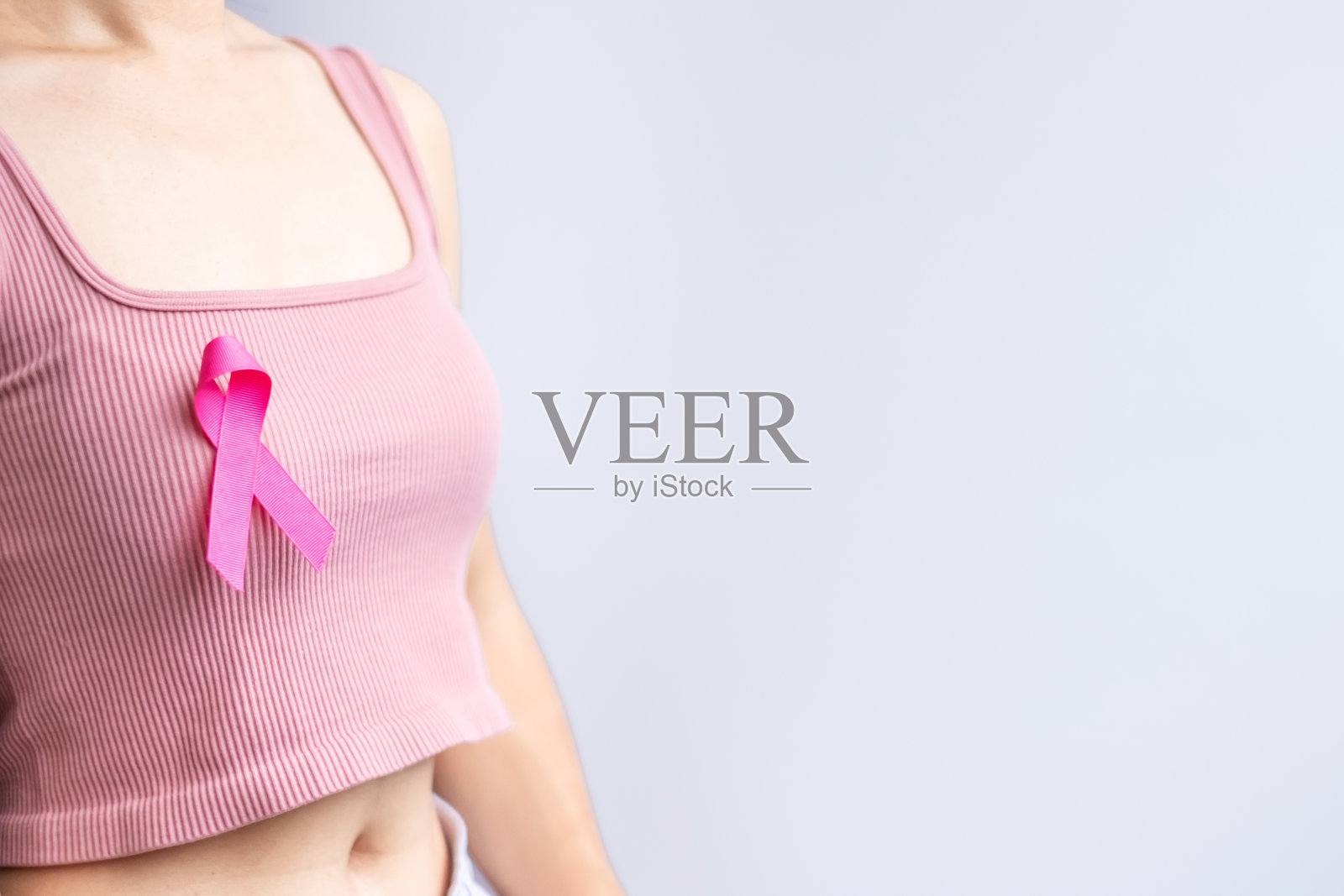 粉红十月乳腺癌宣传月，妇女手拿粉红丝带，穿着衬衫，支持人们的生命和疾病。全国癌症幸存者月，母亲和世界癌症日的概念照片摄影图片