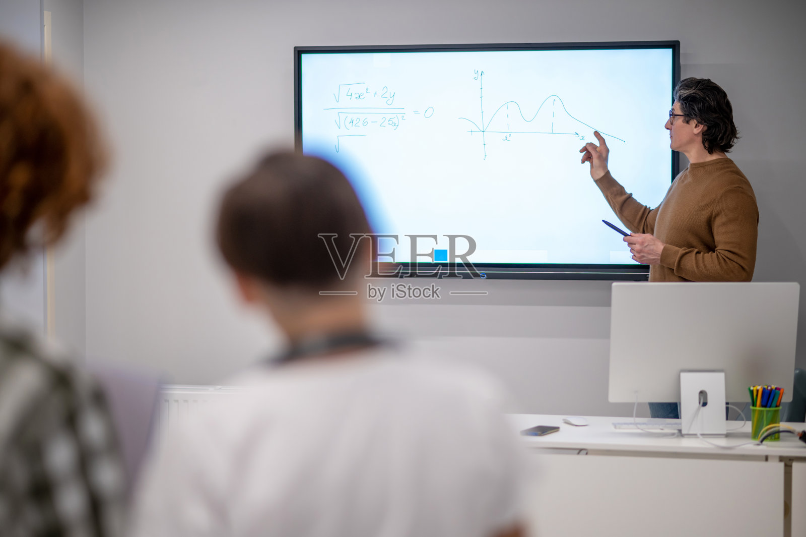 一位学校老师在数学课上讲解新话题照片摄影图片