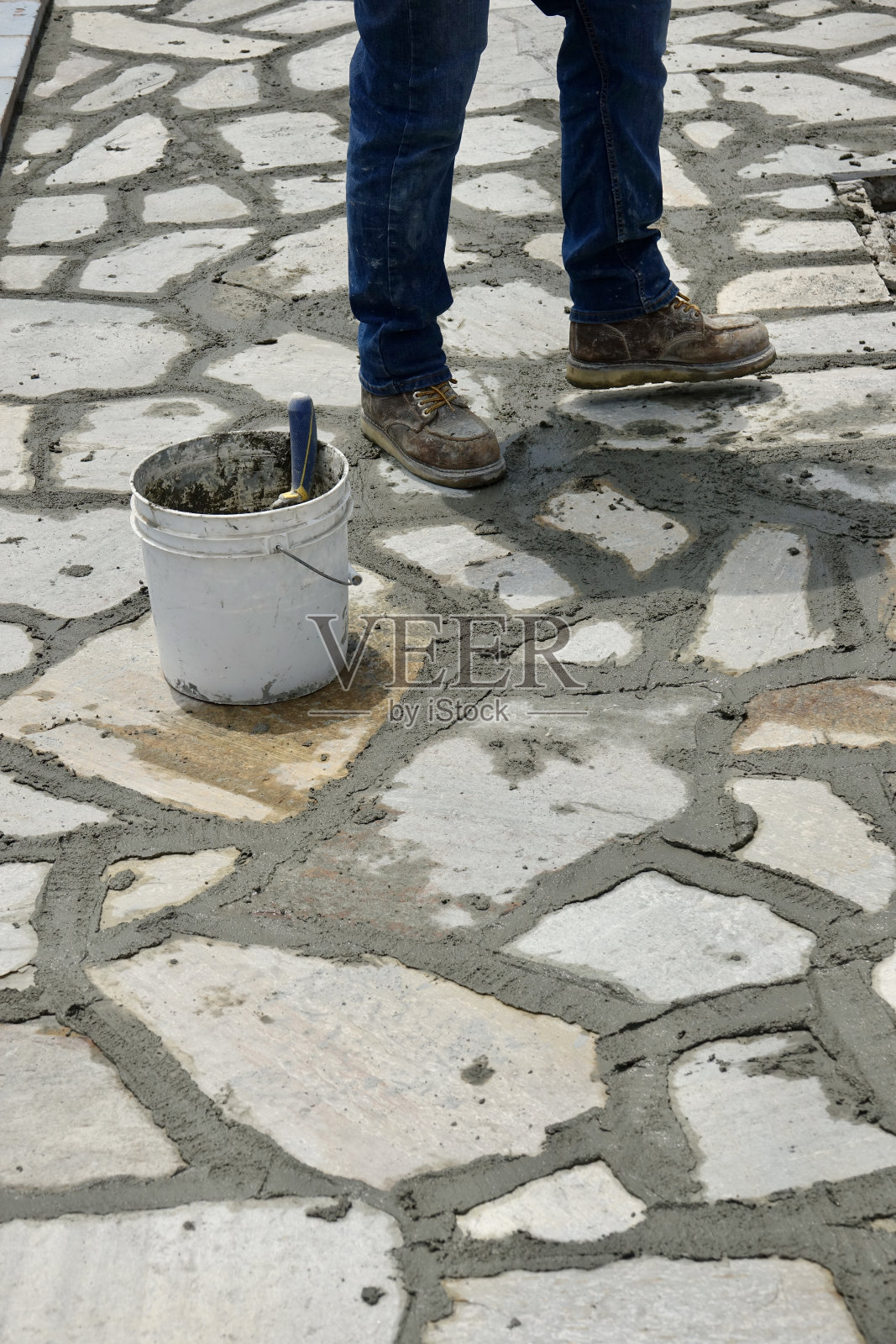 石匠在石头之间的缝隙中灌浆照片摄影图片