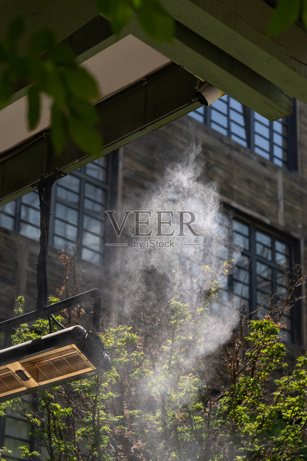 通过喷水来降低温度的设备。水雾机在炎热的夏天工作照片摄影图片