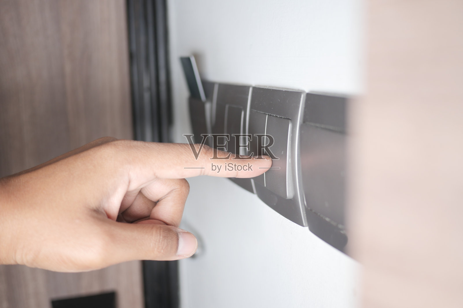 打开照明开关的手指。照片摄影图片