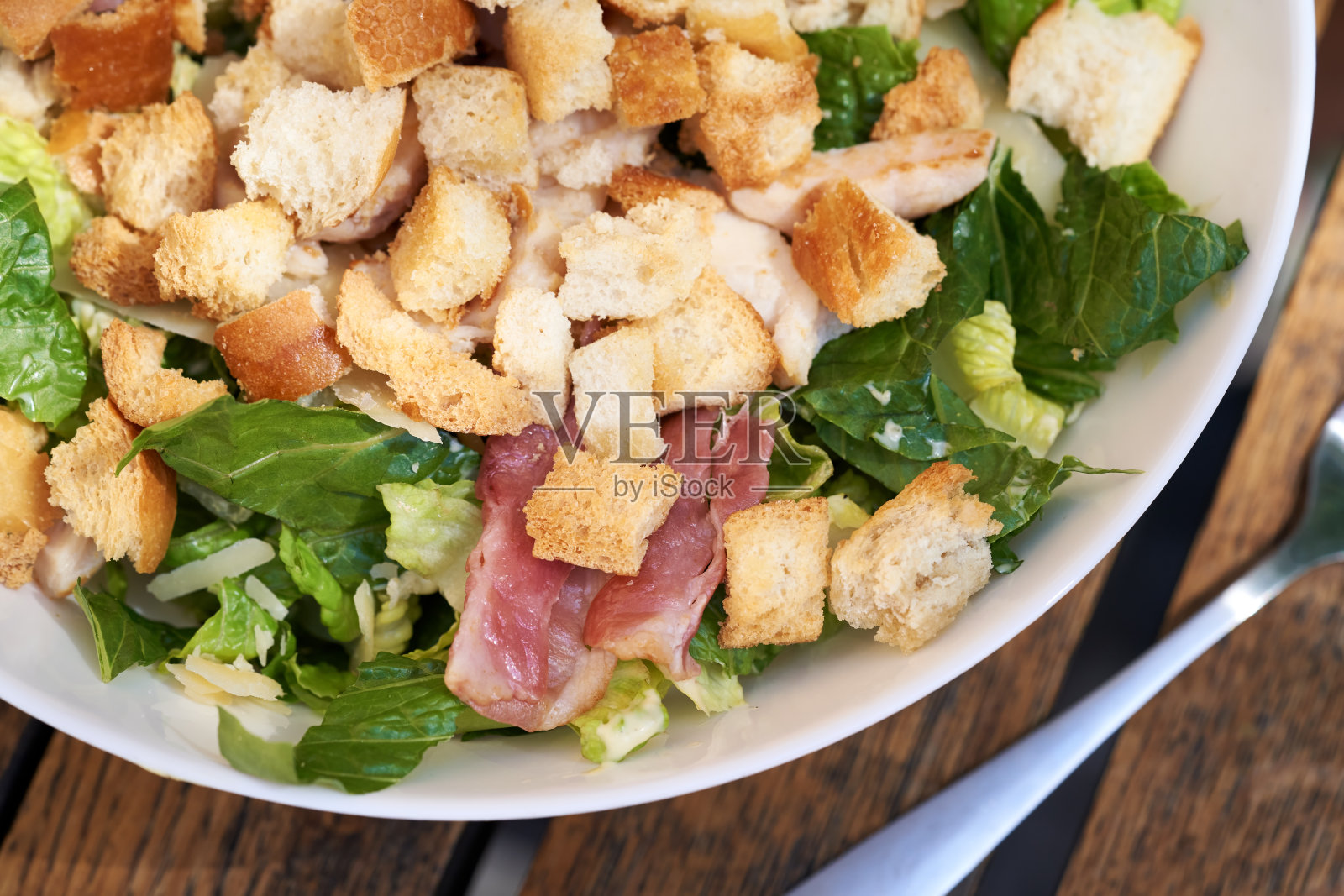 凯撒沙拉配面包丁、生菜、培根和鸡肉照片摄影图片