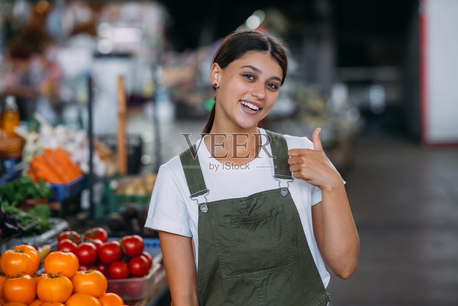 在柜台卖蔬菜的女人。中小企业的概念照片摄影图片