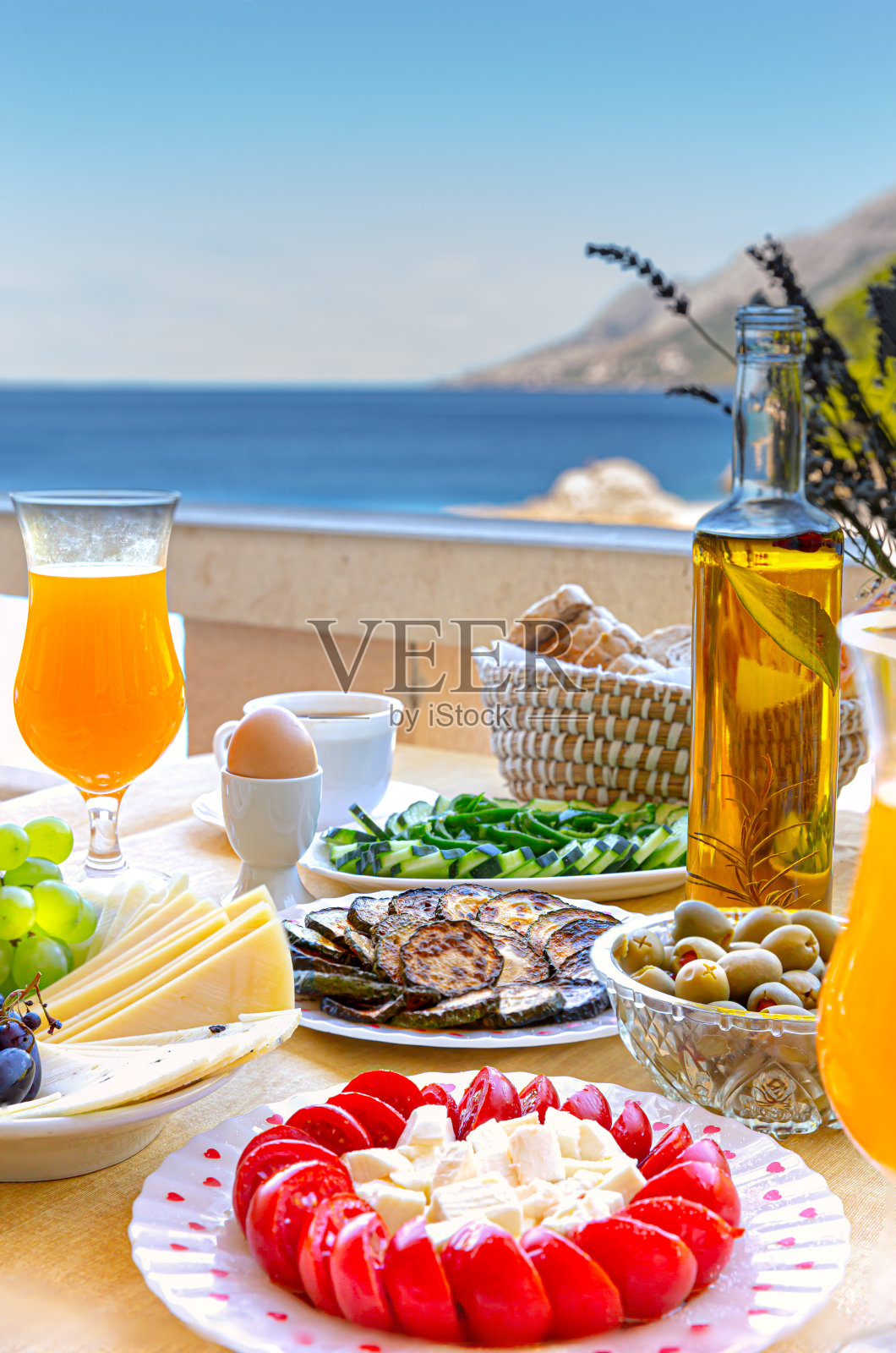 自制新鲜的夏日早餐，橙汁，圣女果，奶酪，橄榄，黄瓜，鸡蛋一杯咖啡，阳台海景。背景概念的想法。照片摄影图片