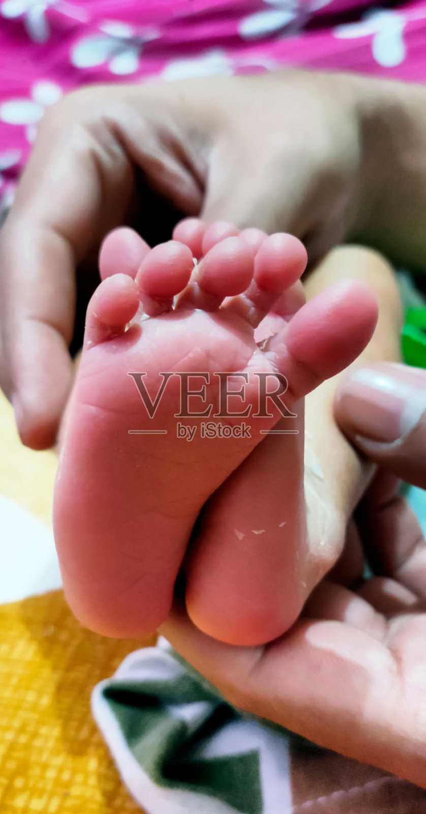 特写的小新生婴儿的脚在女性的手照片摄影图片