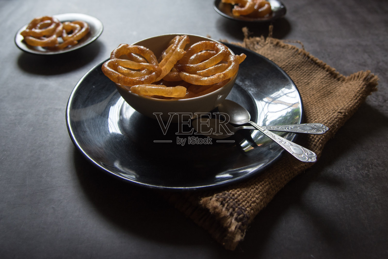 装在黑色托盘上的印度甜加勒比或imarti。照片摄影图片