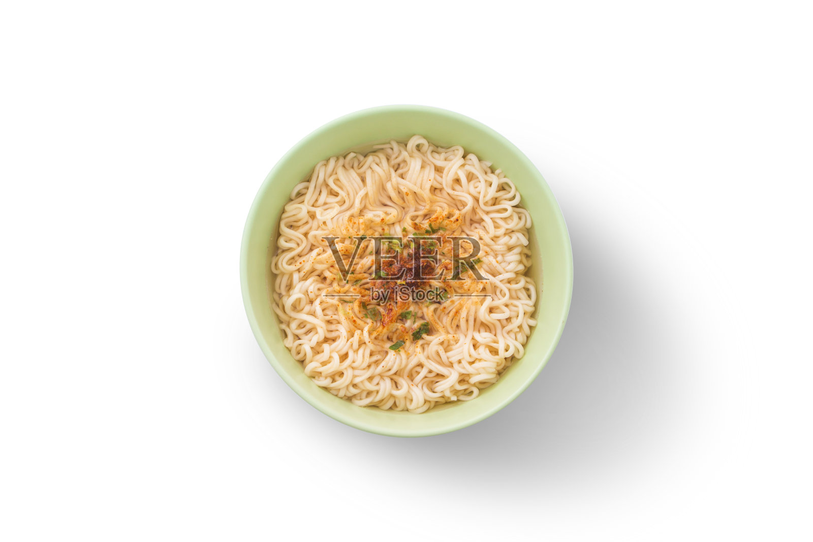 黄色的面条和佐料在绿色杯孤立在白色的背景。照片摄影图片