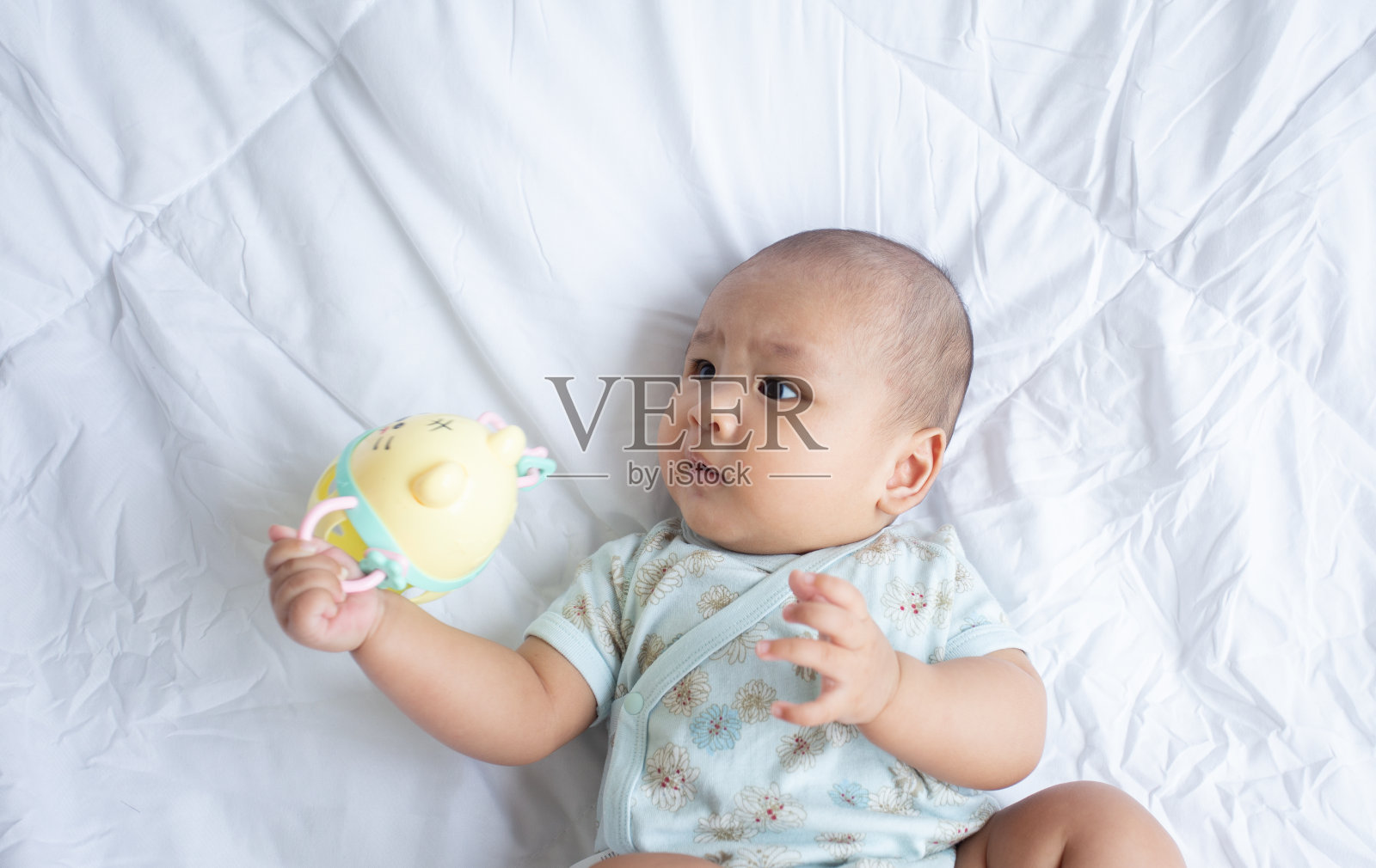 亚洲可爱宝宝在白色阳光充足的卧室。新生儿躺在床上放松照片摄影图片